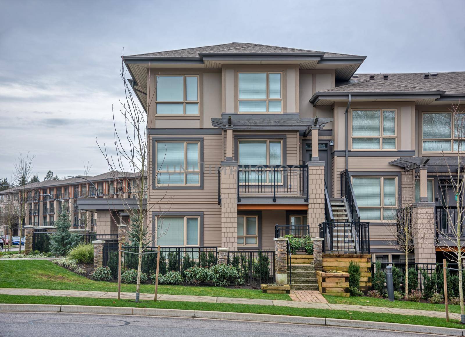 Residential apartment buildings on overcast sky background with concrete pathway in front