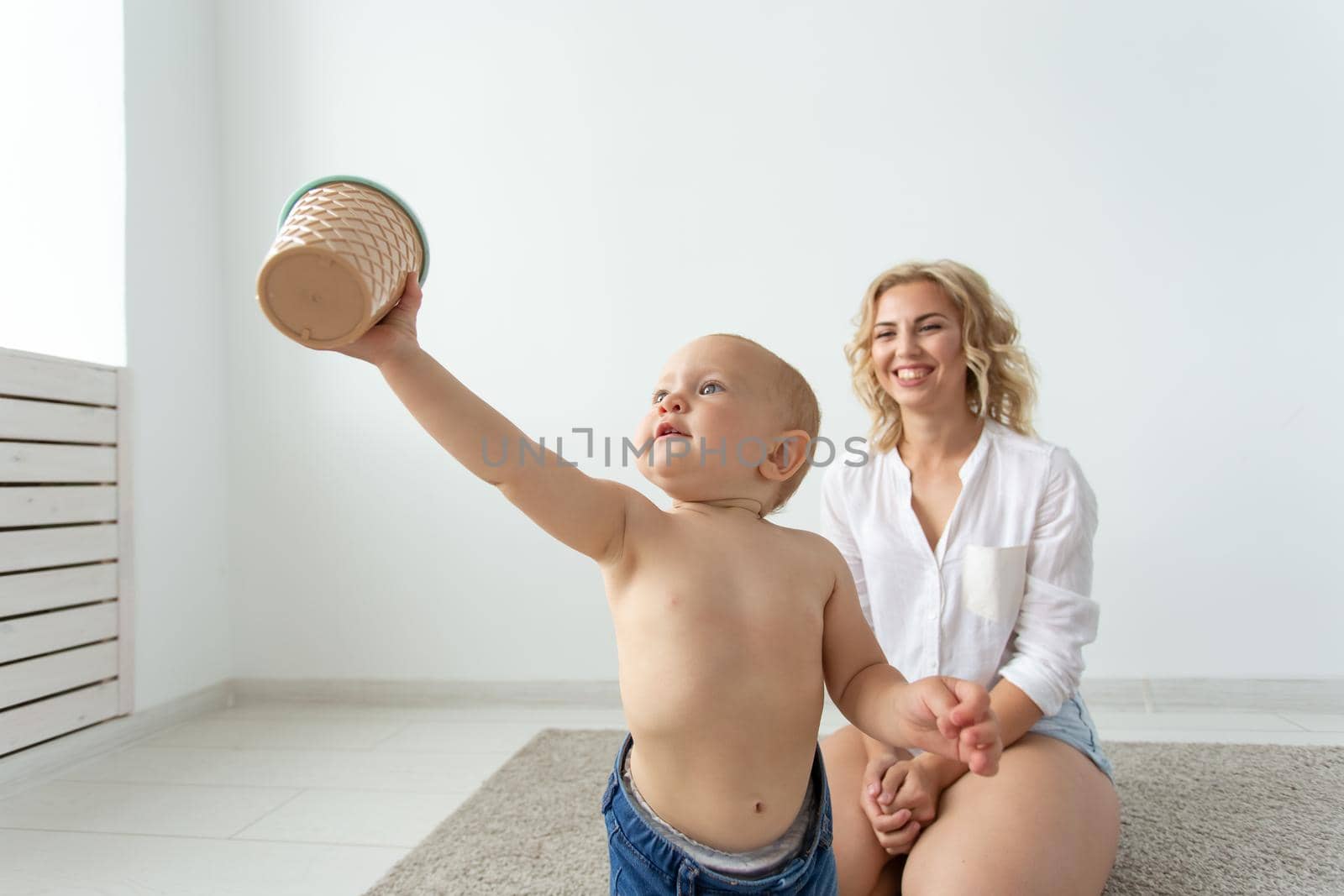Family and childhood concept - Portrait of mother and baby playing and smiling at home