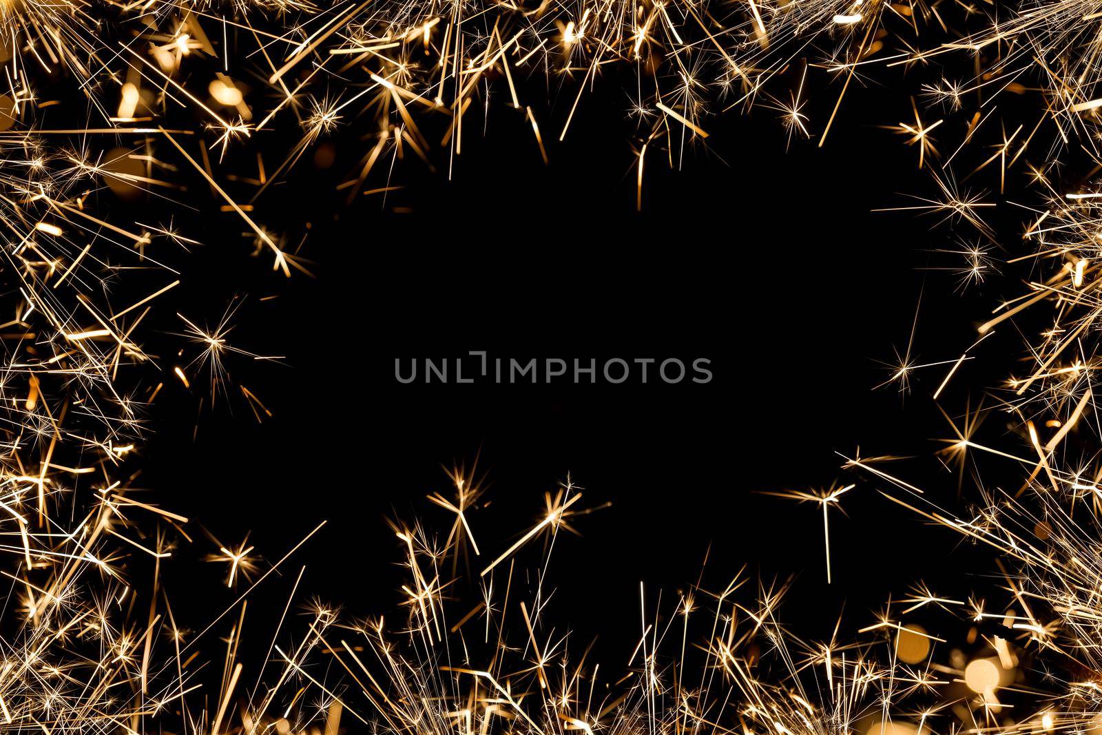 Border frame of many bright firework sparklers over black with copy space, background for Christmas, wedding and Independence Day projects