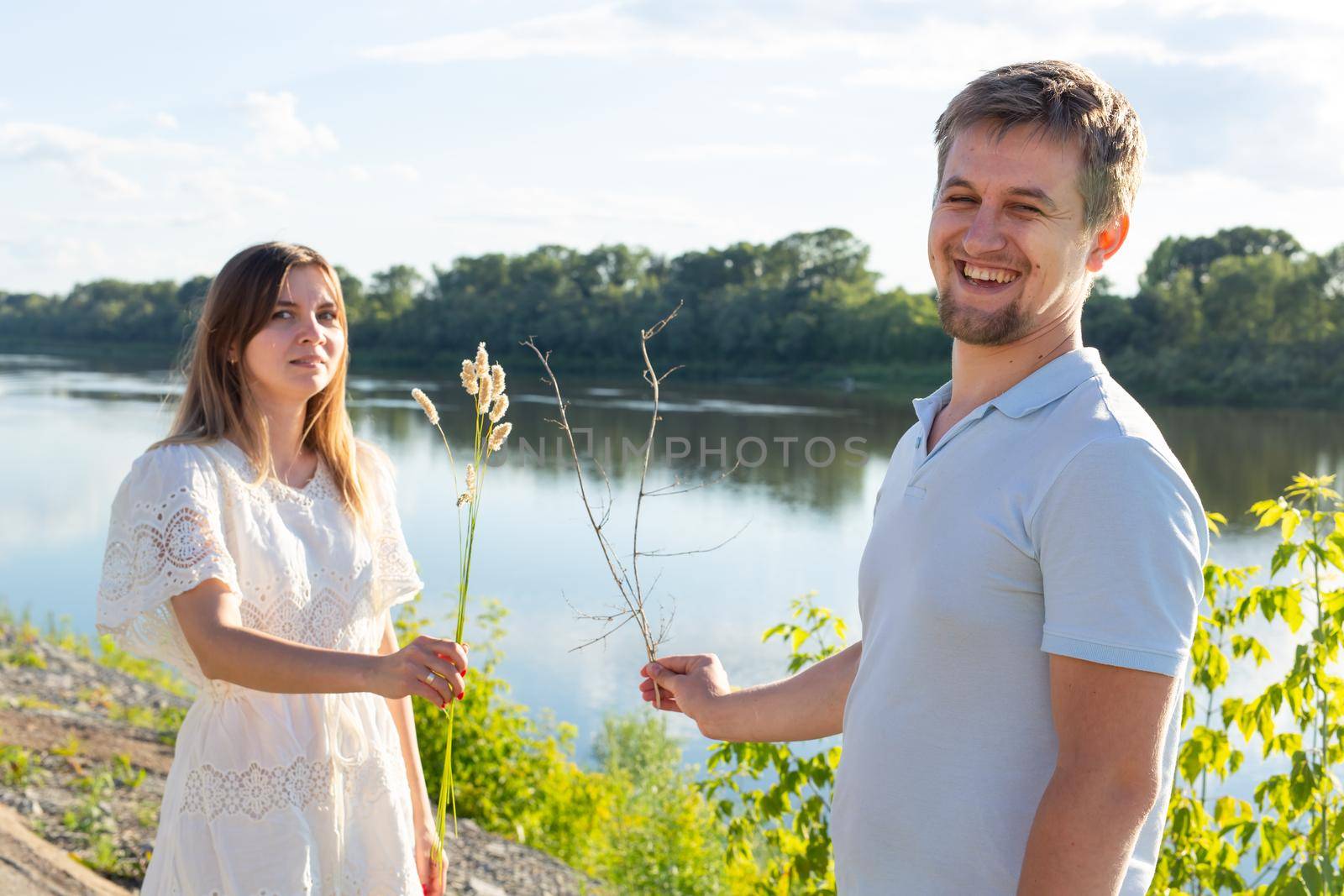 Joke, relationship and humor concept - Portrait of a funny love couple fooling around on nature by Satura86