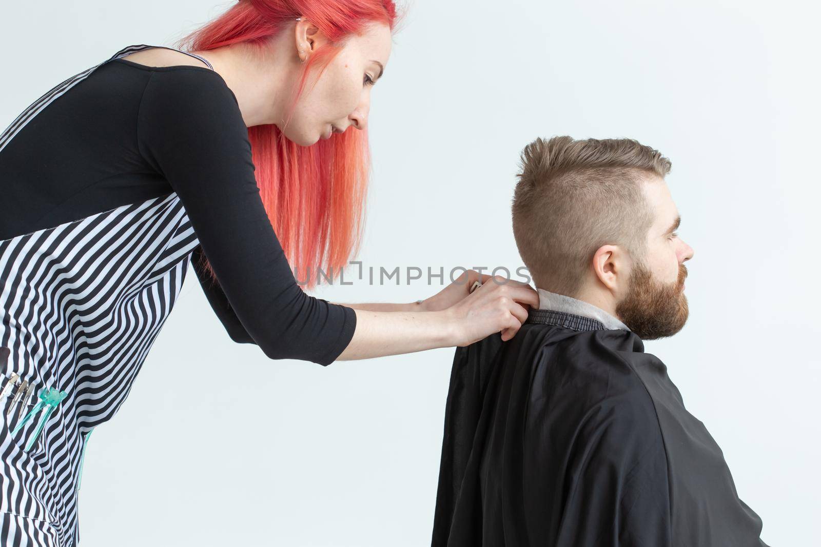 Hairdresser, stylist and barber shop concept - woman hairstylist cutting a man.