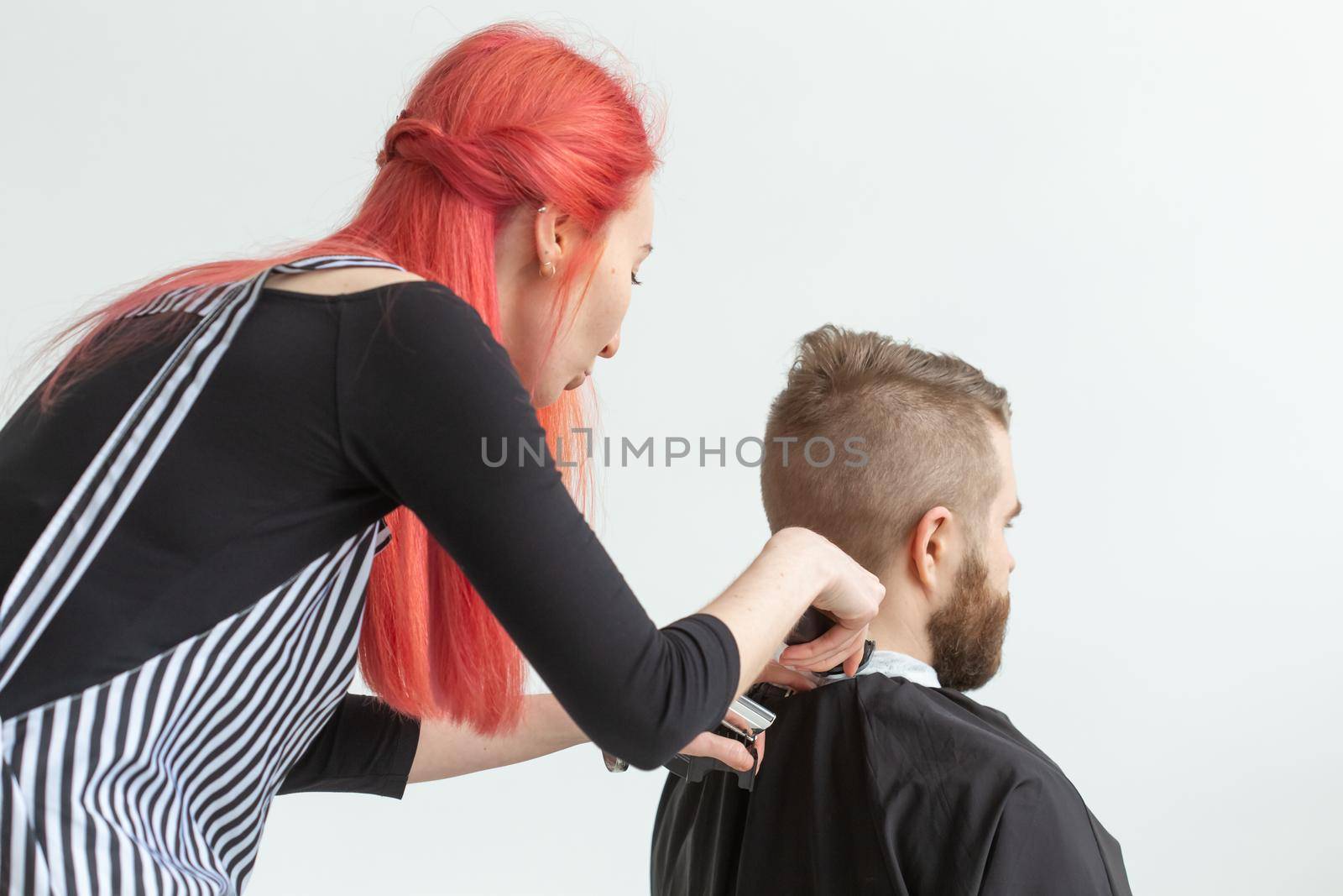 Hairdresser, stylist and barber shop concept - woman hairstylist cutting a man.