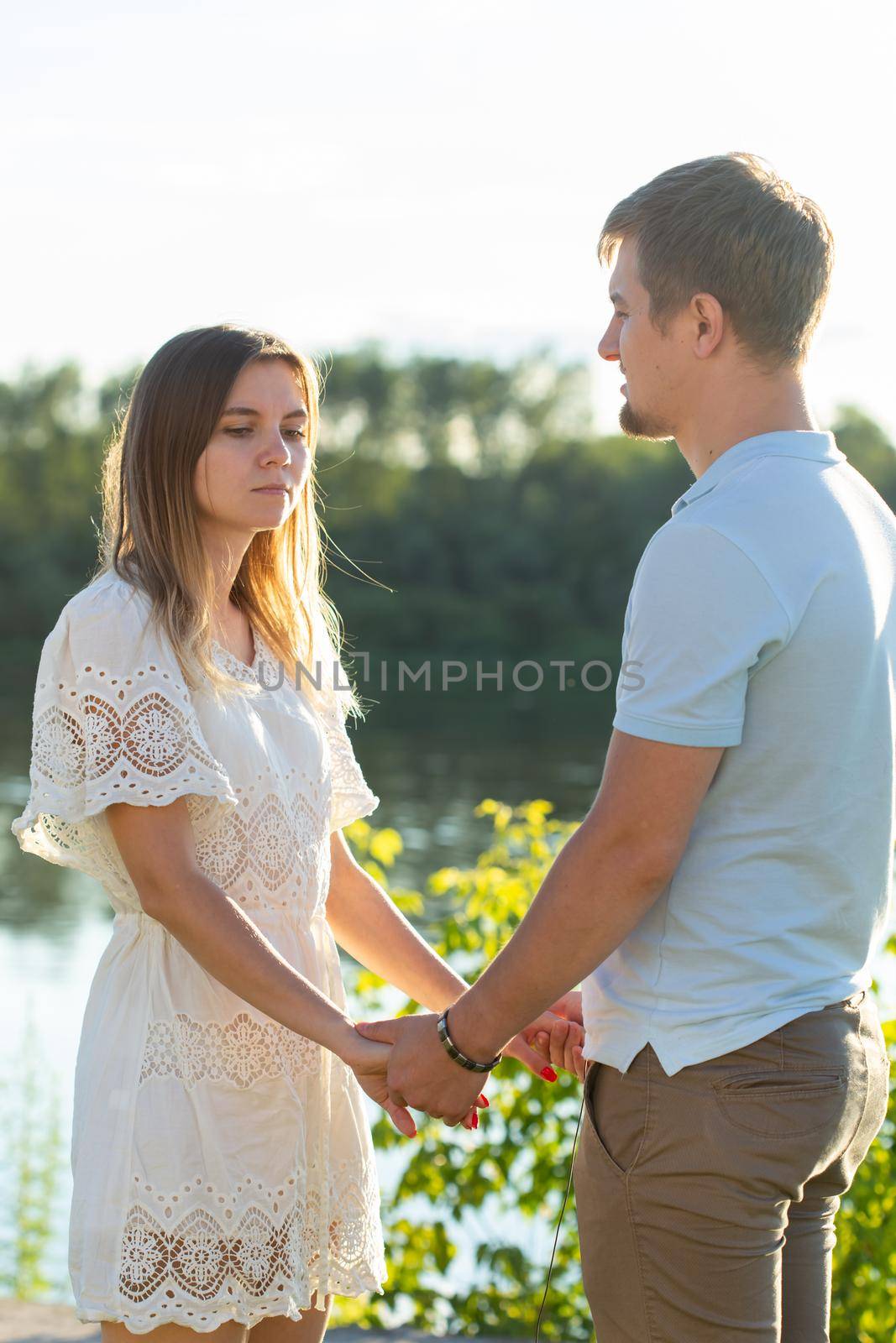 Man and woman holding hands on summer nature. Couple in romantic embrace by Satura86