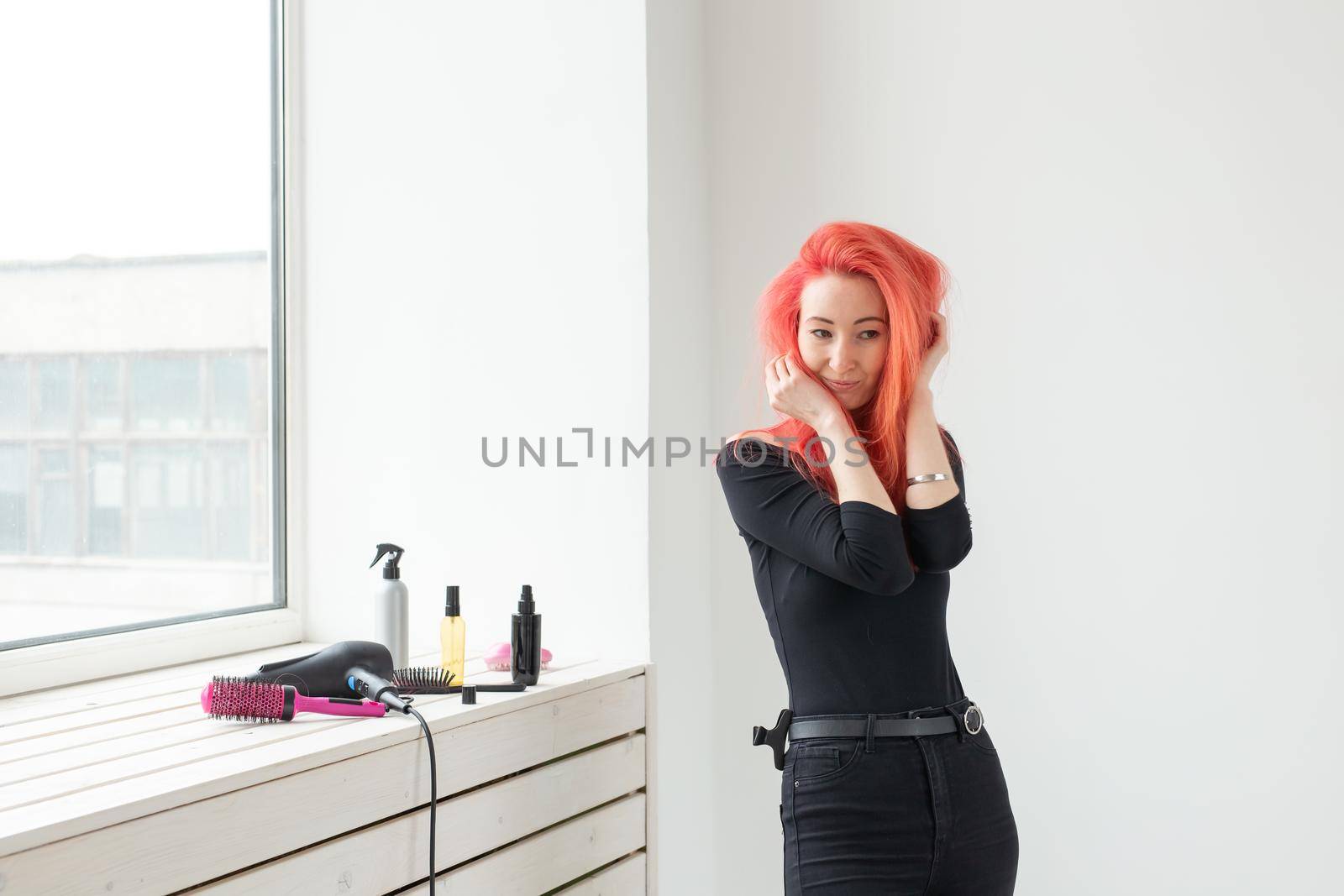 young beautiful woman combing her hair in living room.