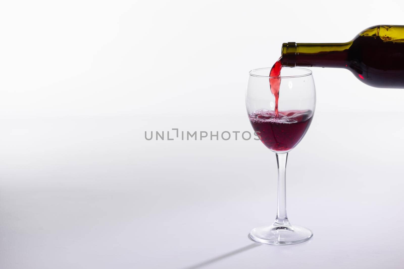 Red wine bottle pour glass on white background with copy space by Satura86