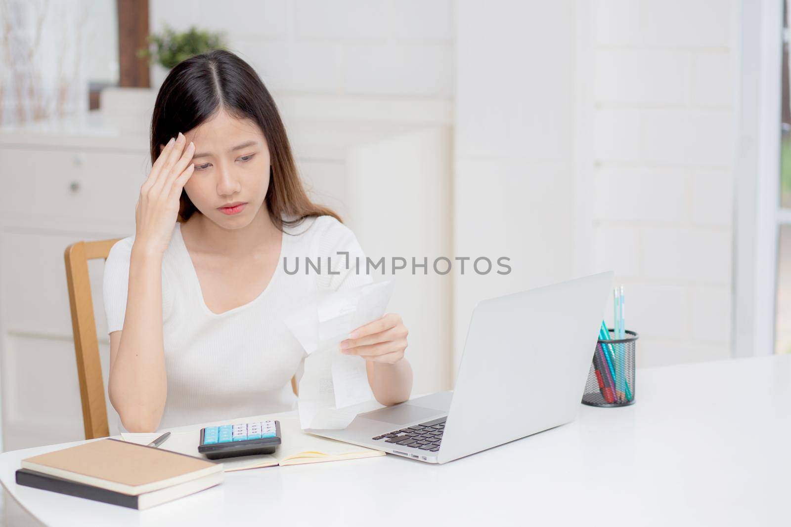 Young asian woman calculating expenses household about finance and frustrated on desk at home, girl checking bill having stress and worried, debt and tax, expression and emotion, business concept. by nnudoo