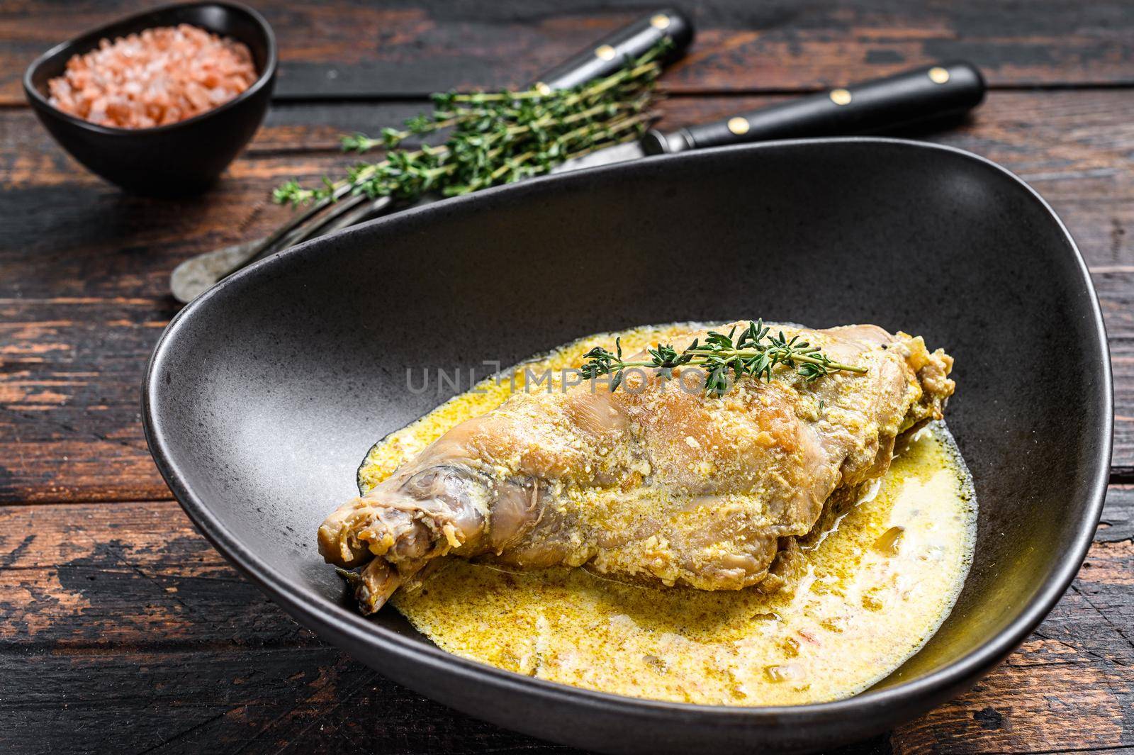 Stew with hare legs with rosemary and garlic. Wooden background. Top view by Composter