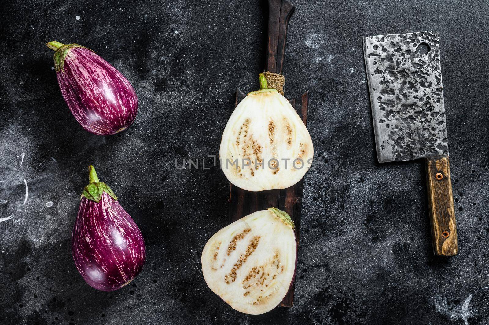 Sliced raw small purple Asian eggplants. Black background. Top view.