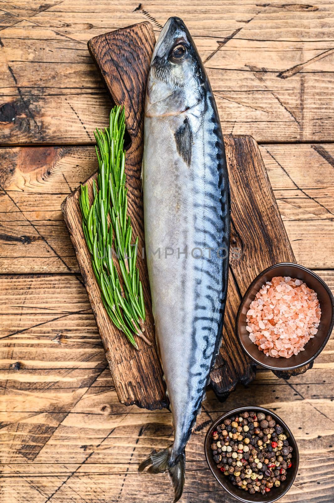 Raw saltwater fish Mackerel on a wooden cutting board with a thyme. wooden background. Top view.