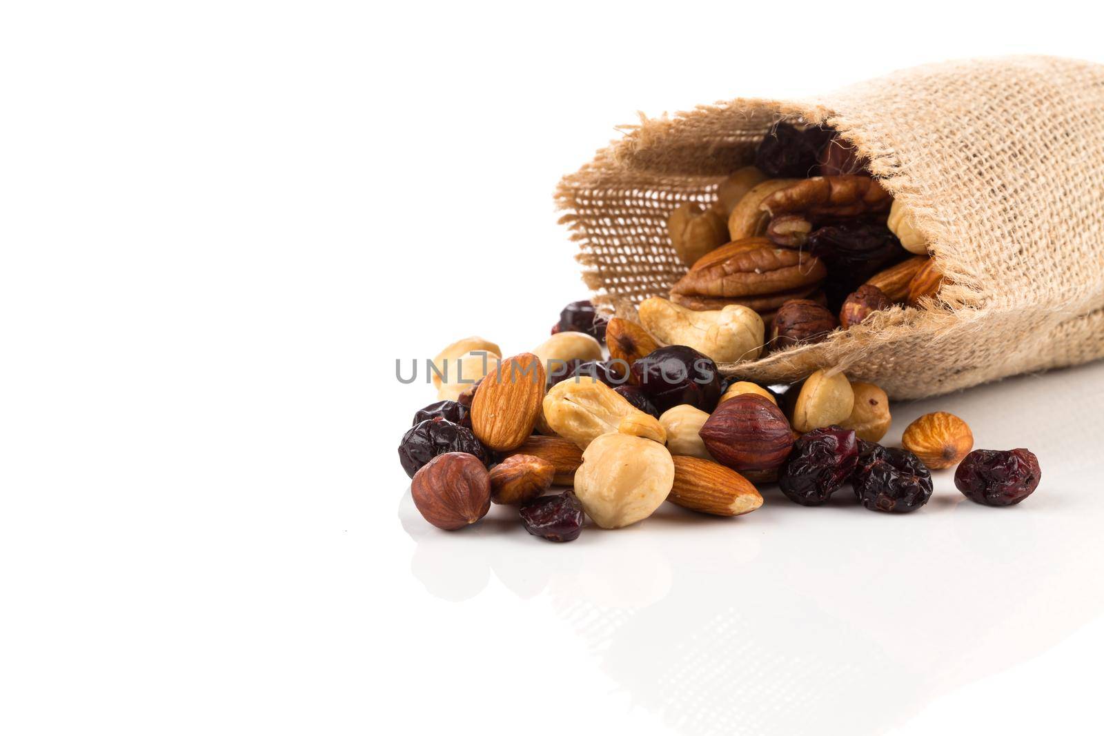 Mix nuts, dry fruits and grapes on a white background in hessian bag