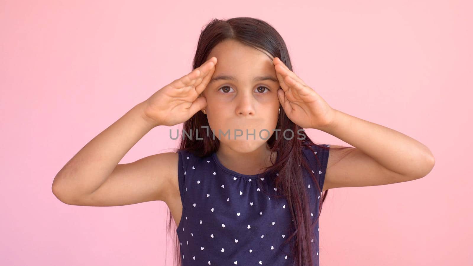 Portrait of an emotional 8-year-old girltaped her mouth. pink background