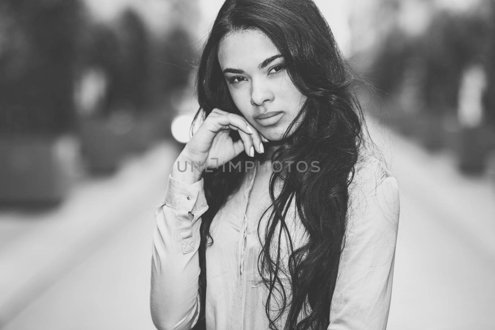 Portrait of hispanic young woman wearing casual clothes in urban background