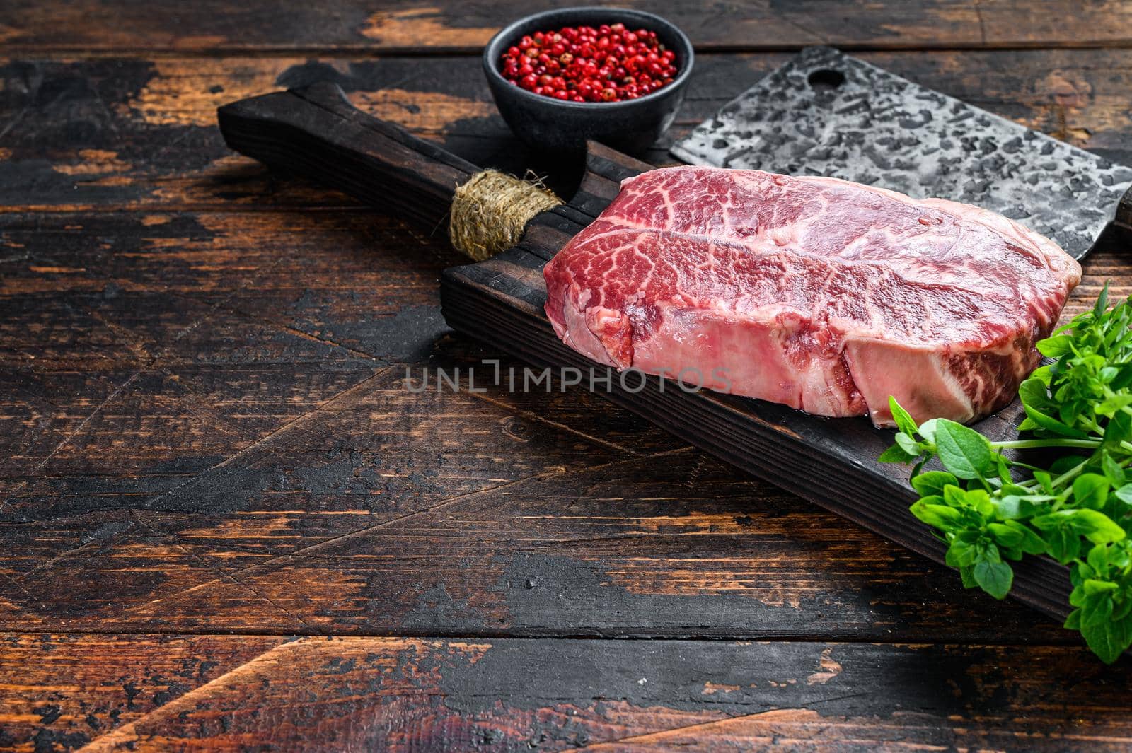 Raw marble beef meat steak. Dark wooden background. Top view. Copy space by Composter