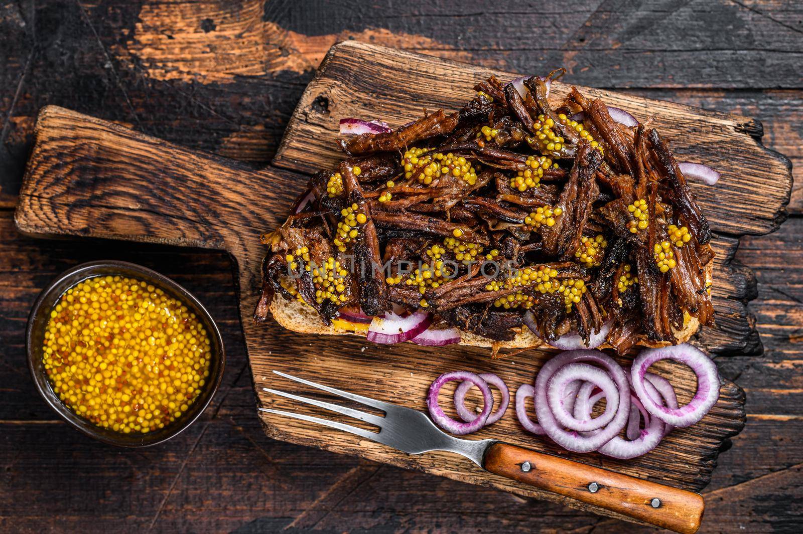 BBQ Texas Sandwich with slow roasted brisket beef meat. Dark wooden background. Top view by Composter