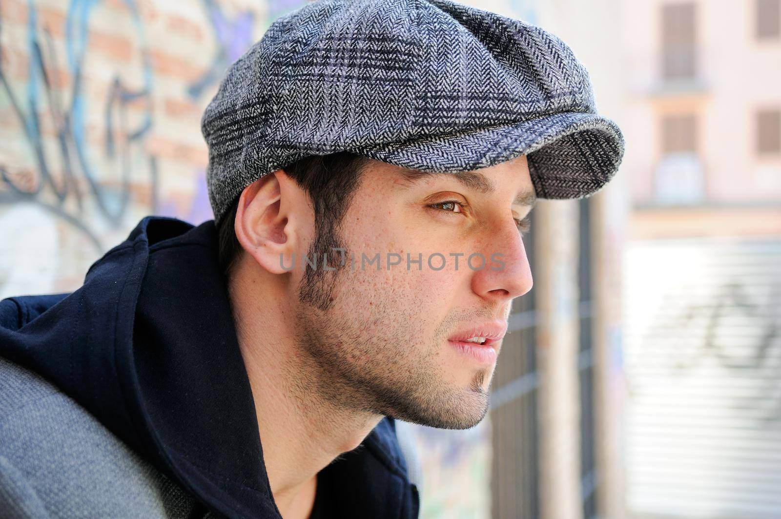 Portrait of handsome man in urban background wearing a retro cap