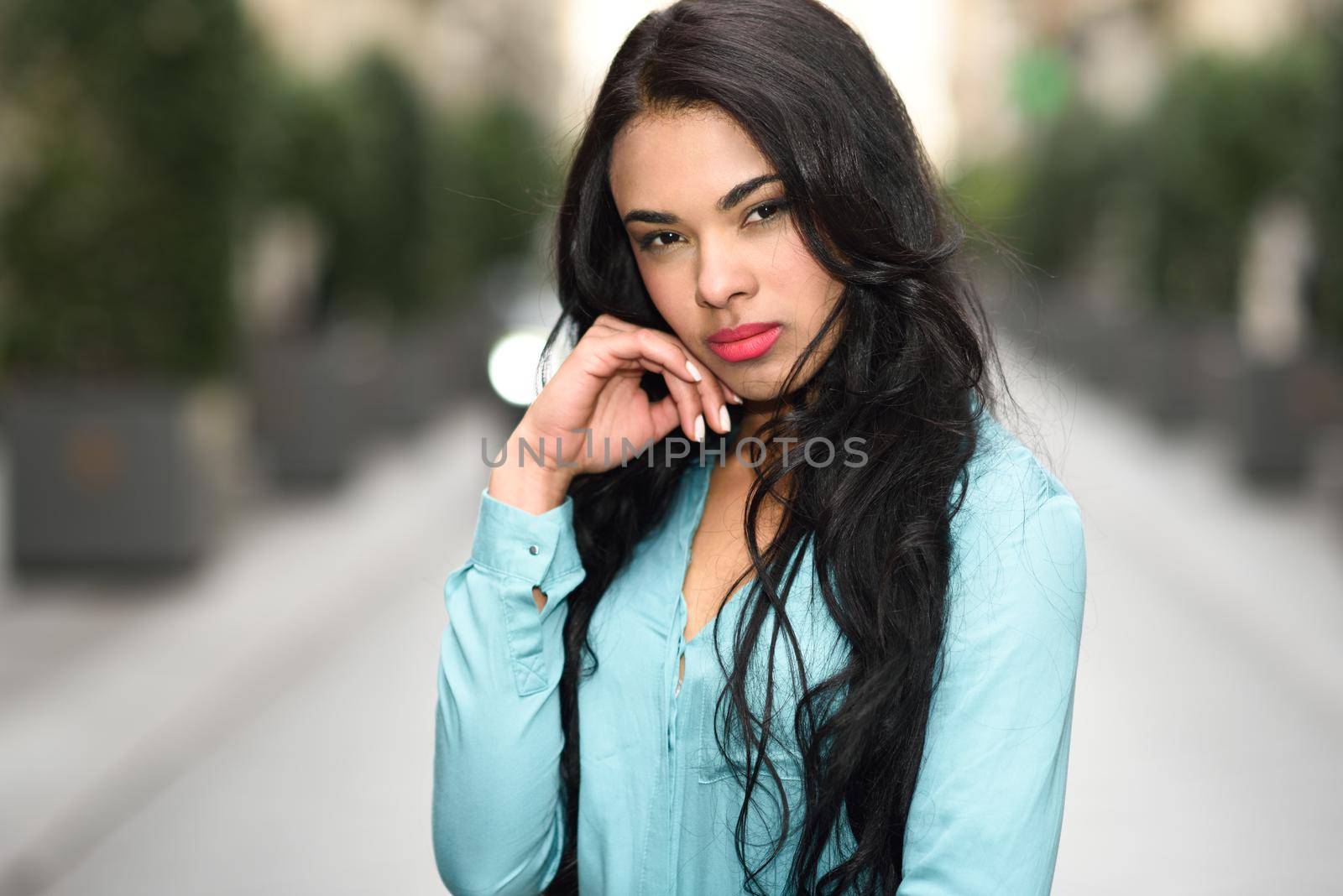Portrait of hispanic young woman wearing casual clothes in urban background