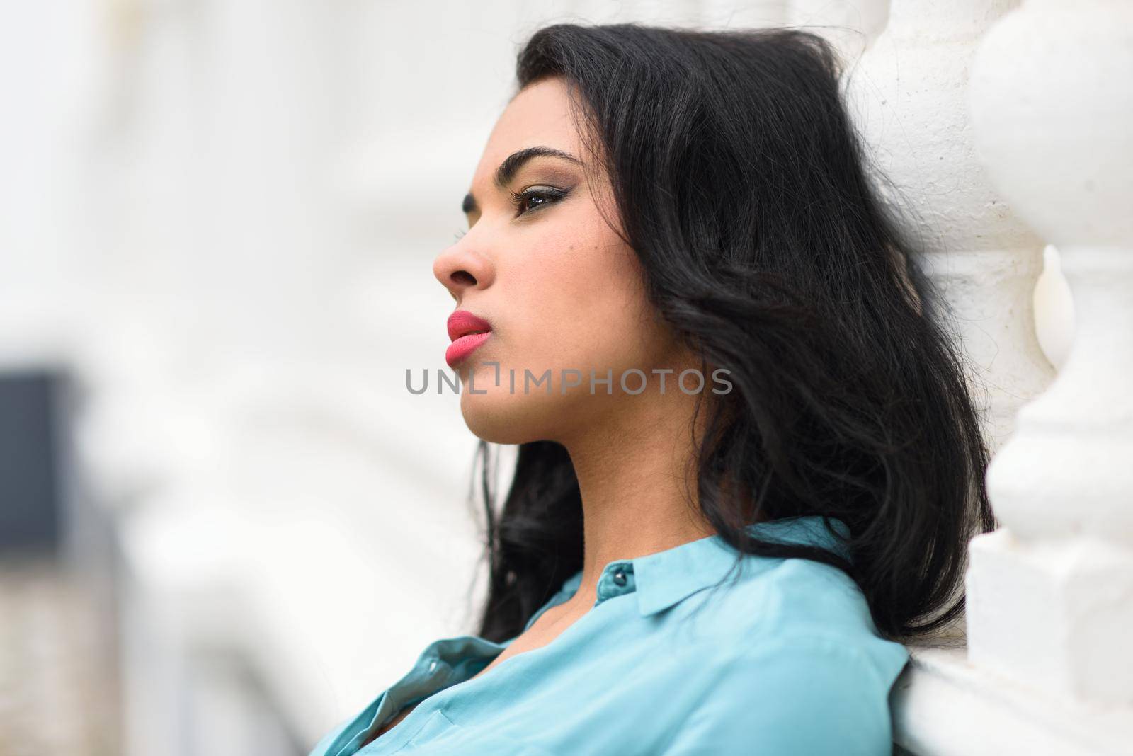 Portrait of hispanic young woman wearing casual clothes in urban background