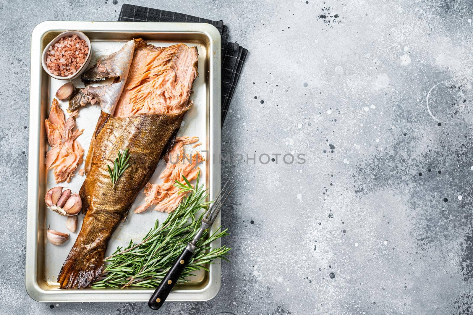 Hot smoked salmon, trout fish with herbs. Gray background. Top view. Copy space.