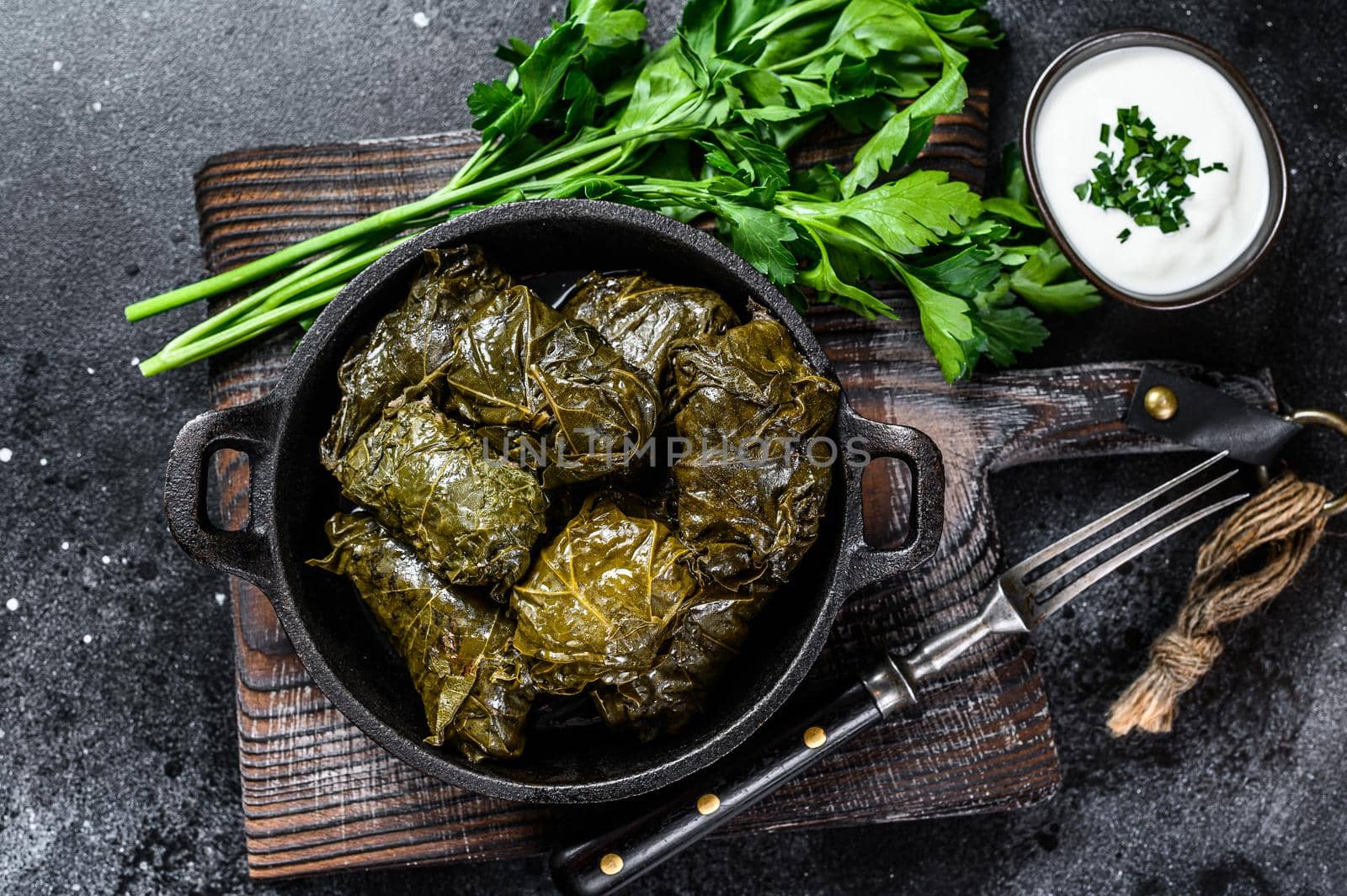 Dolma stuffed grape leaves with rice and meat. Black background. Top view by Composter