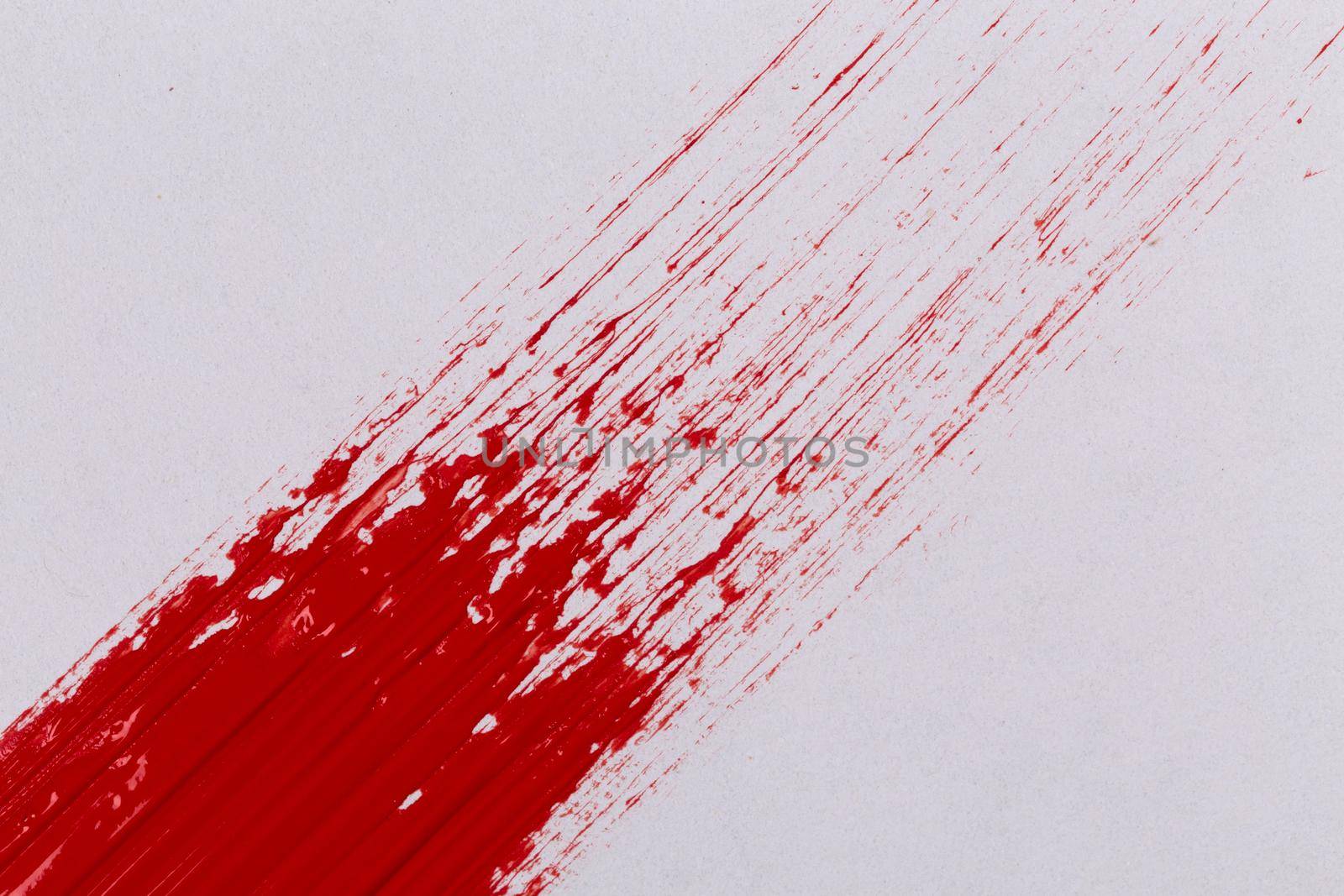 Red paint splash on a white paper