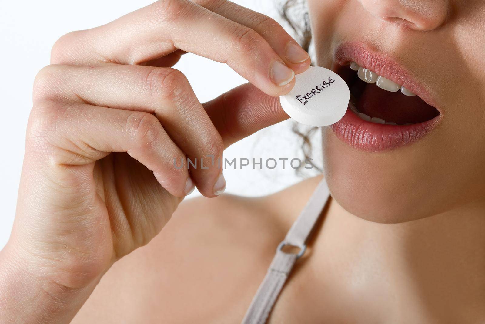Taking sport pills Close-up of a white pill in woman's fingers.