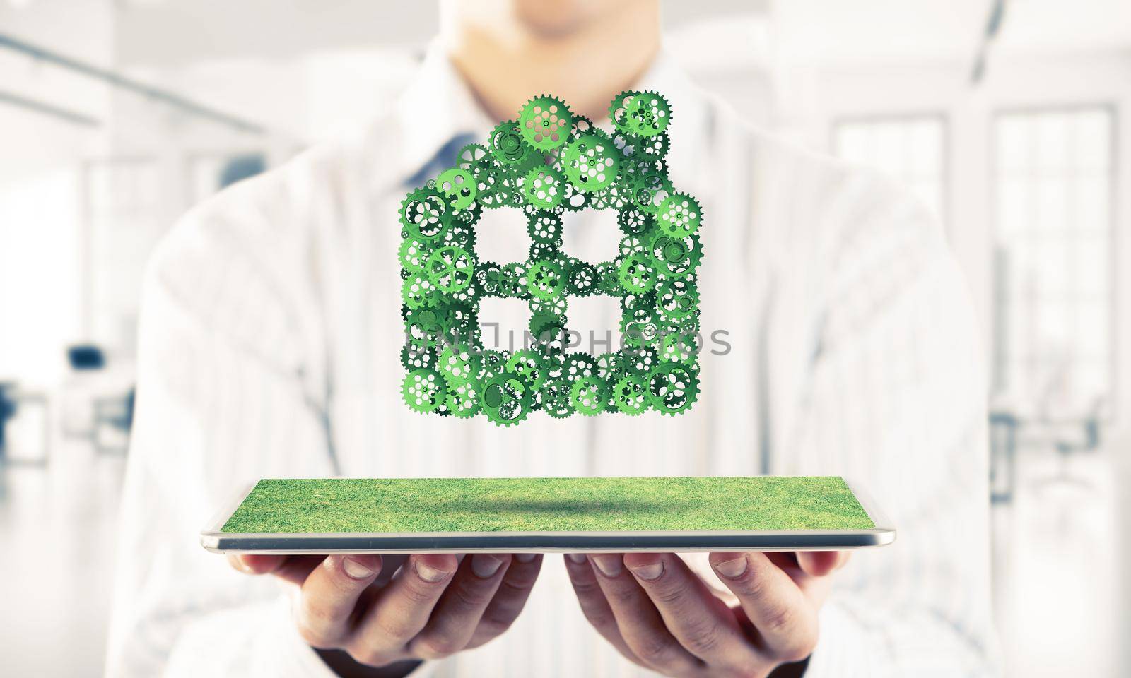 Close of businessman holding tablet pc with house sign made of connected gears. Mixed media