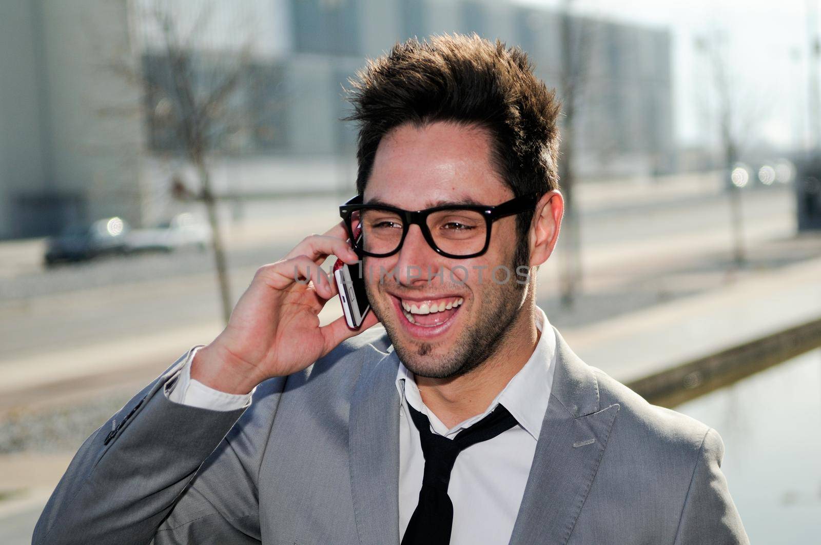 Portrait of handsome man in urban background talking on phone