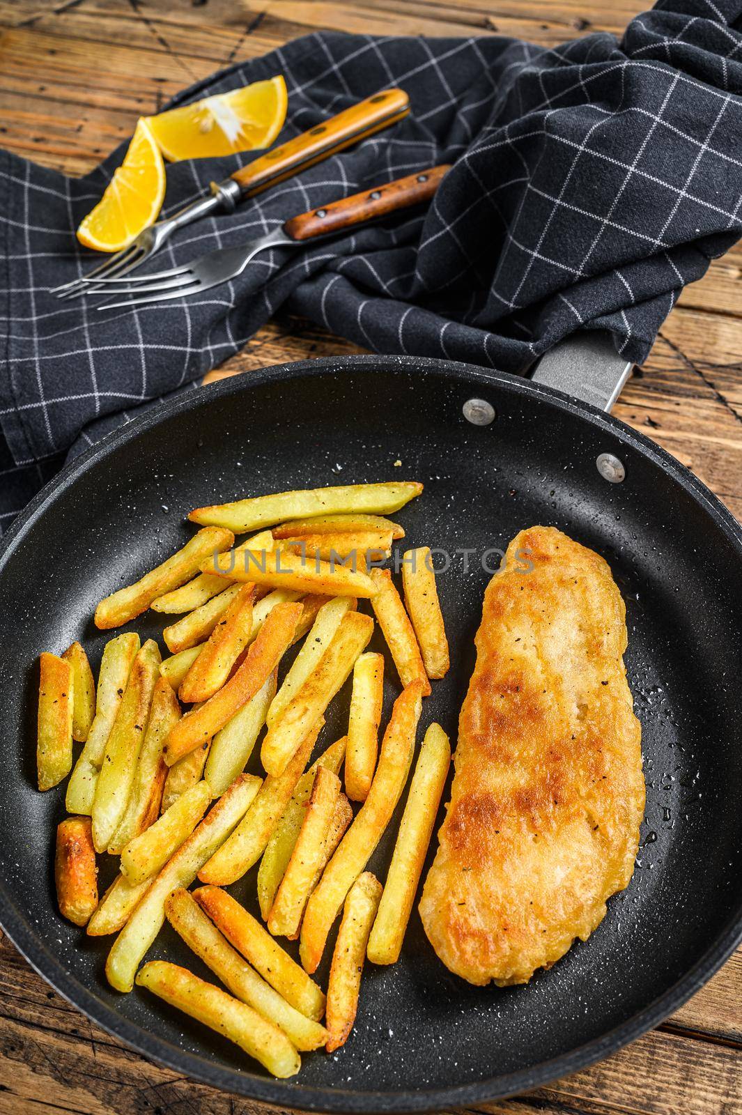 English Traditional Fish and chips dish in a pan. Wooden background. Top view by Composter