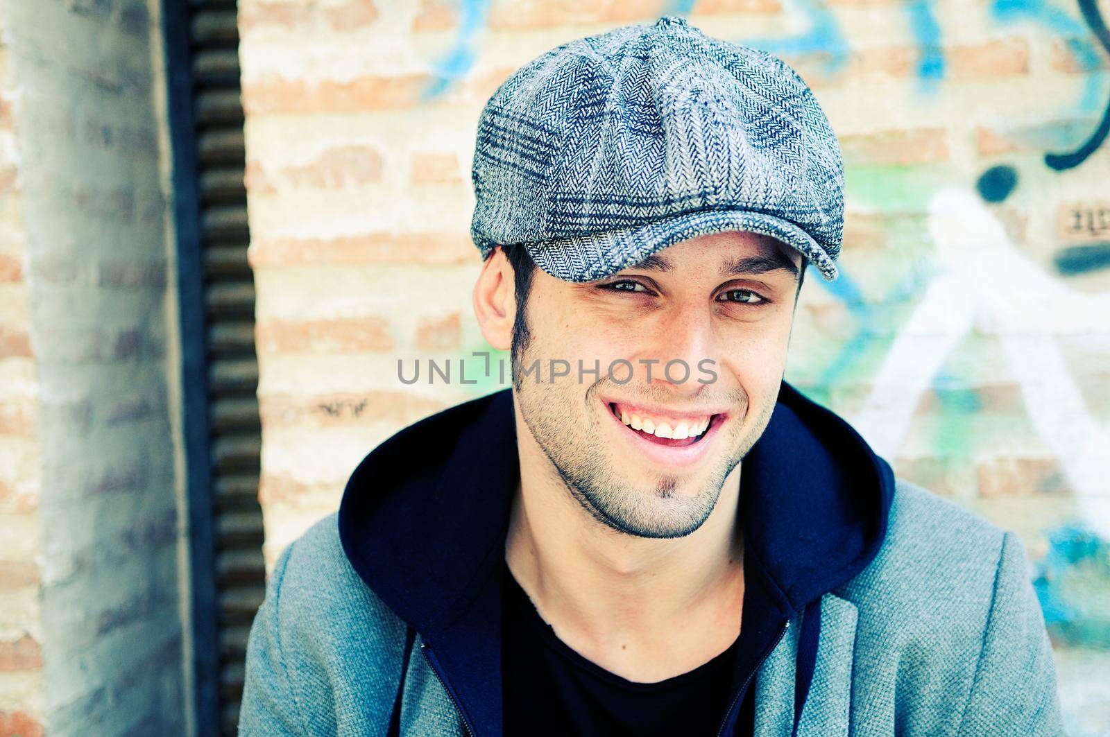 Portrait of handsome man in urban background wearing a retro cap