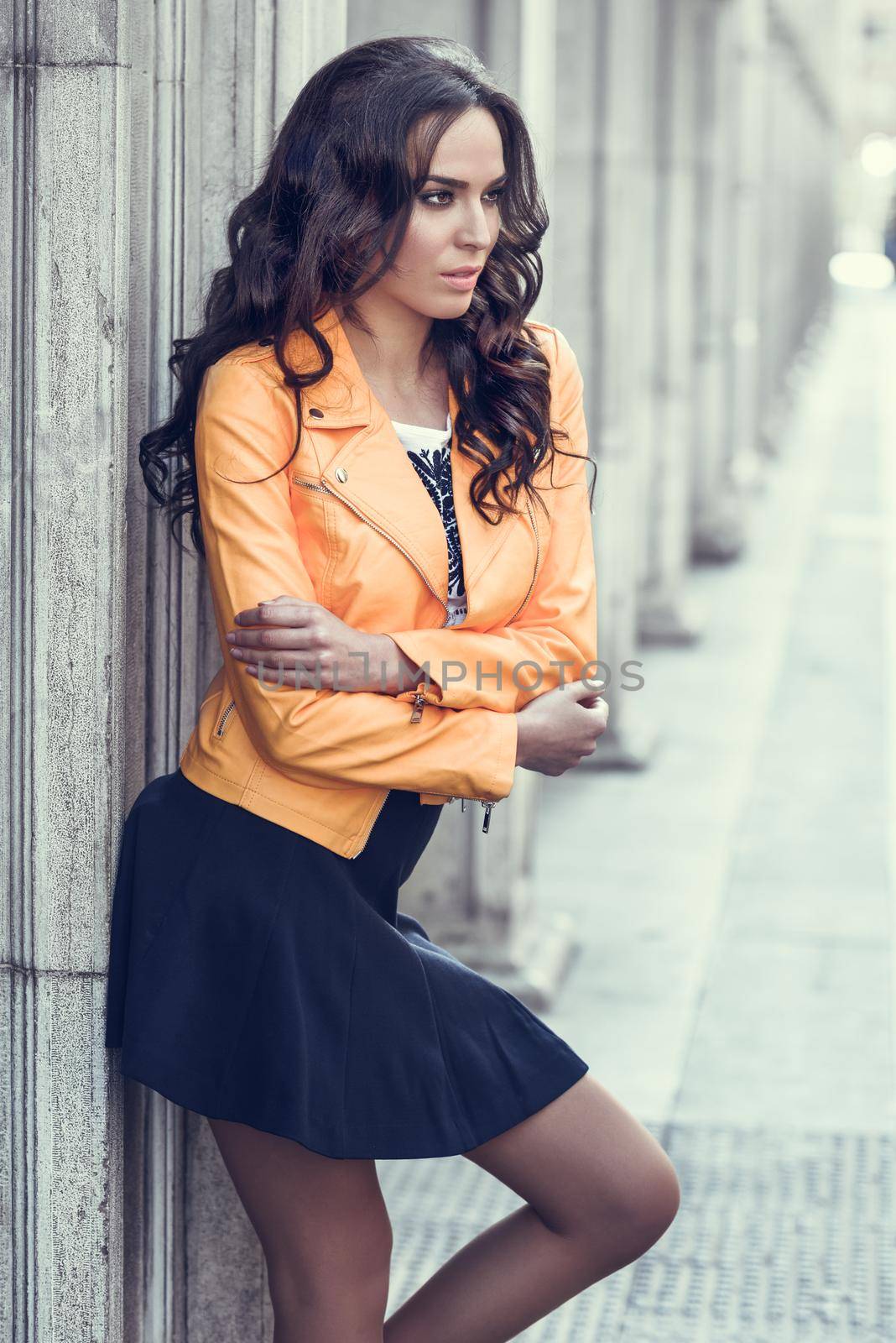 Young brunette woman standing in urban background. by javiindy