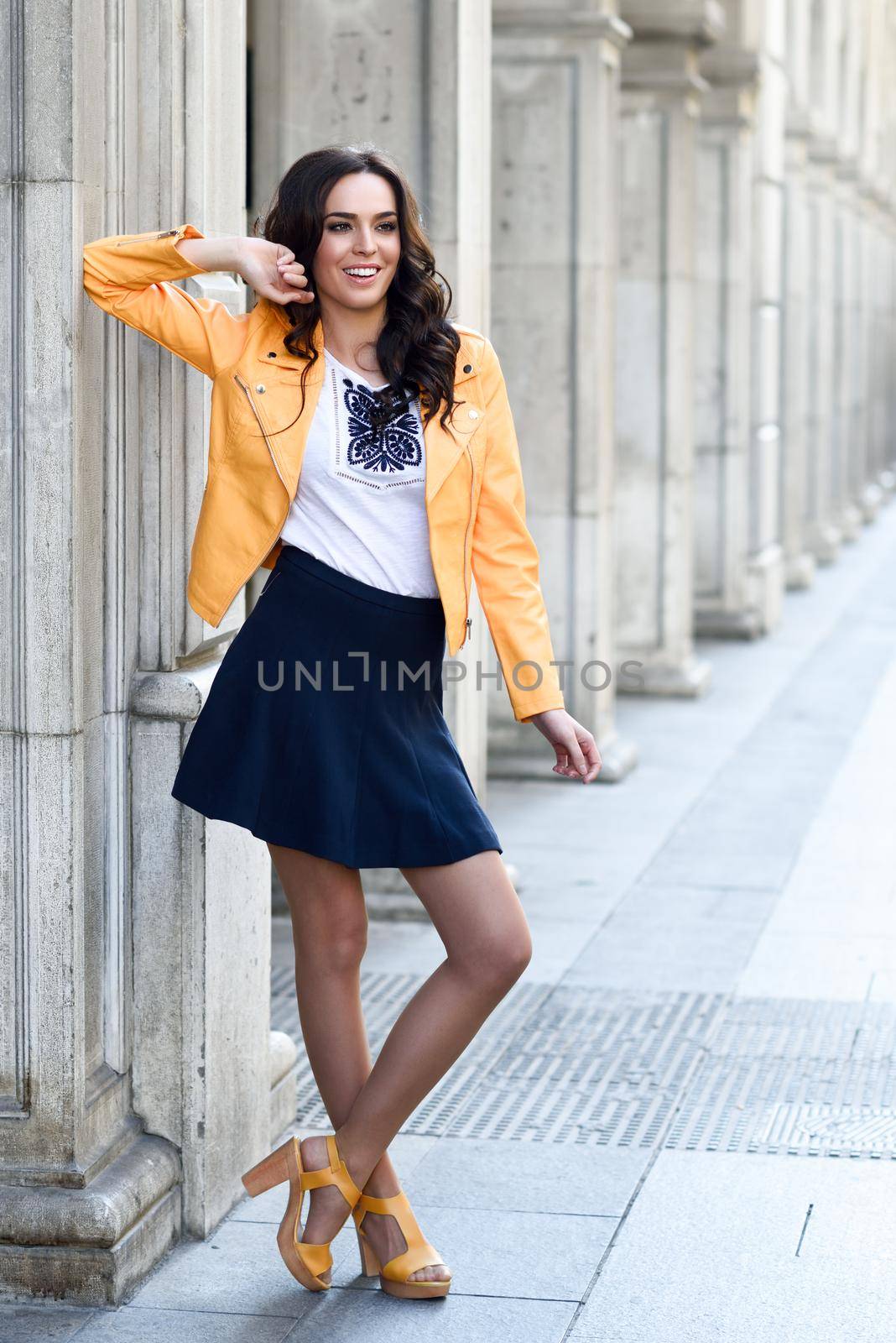 Young brunette woman smiling in urban background. by javiindy