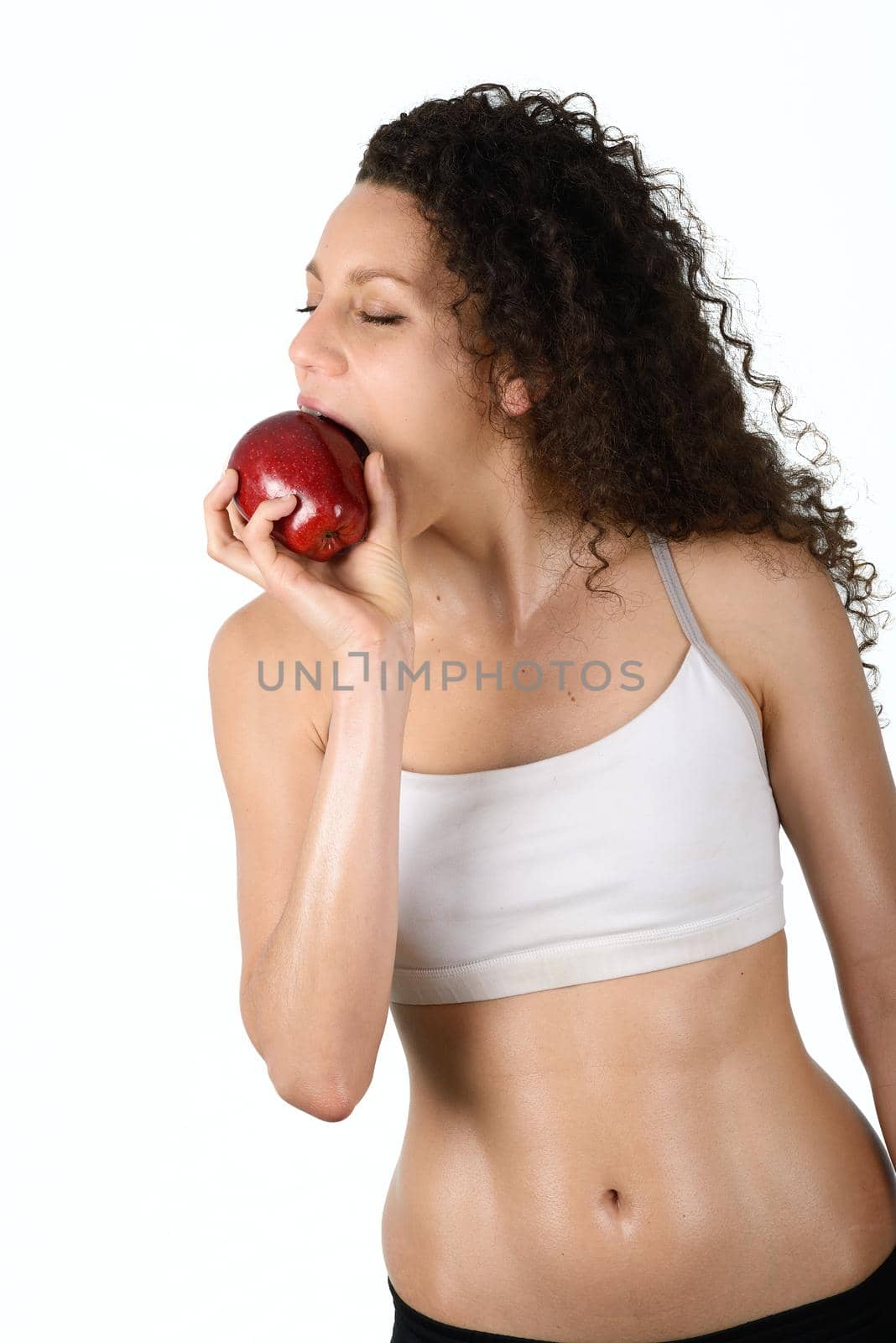 Portrait of beautiful young mixed woman eating an red apple, isolated on white