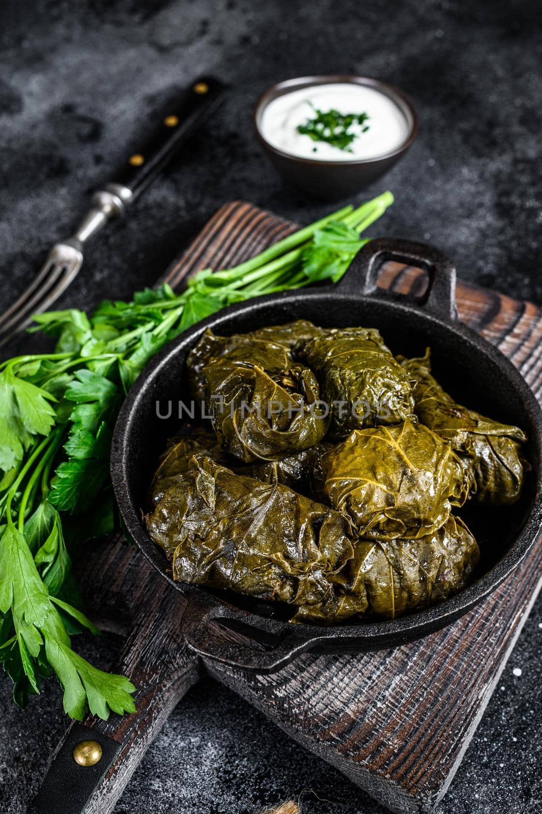 Dolma stuffed grape leaves with rice and meat. Black background. Top view.