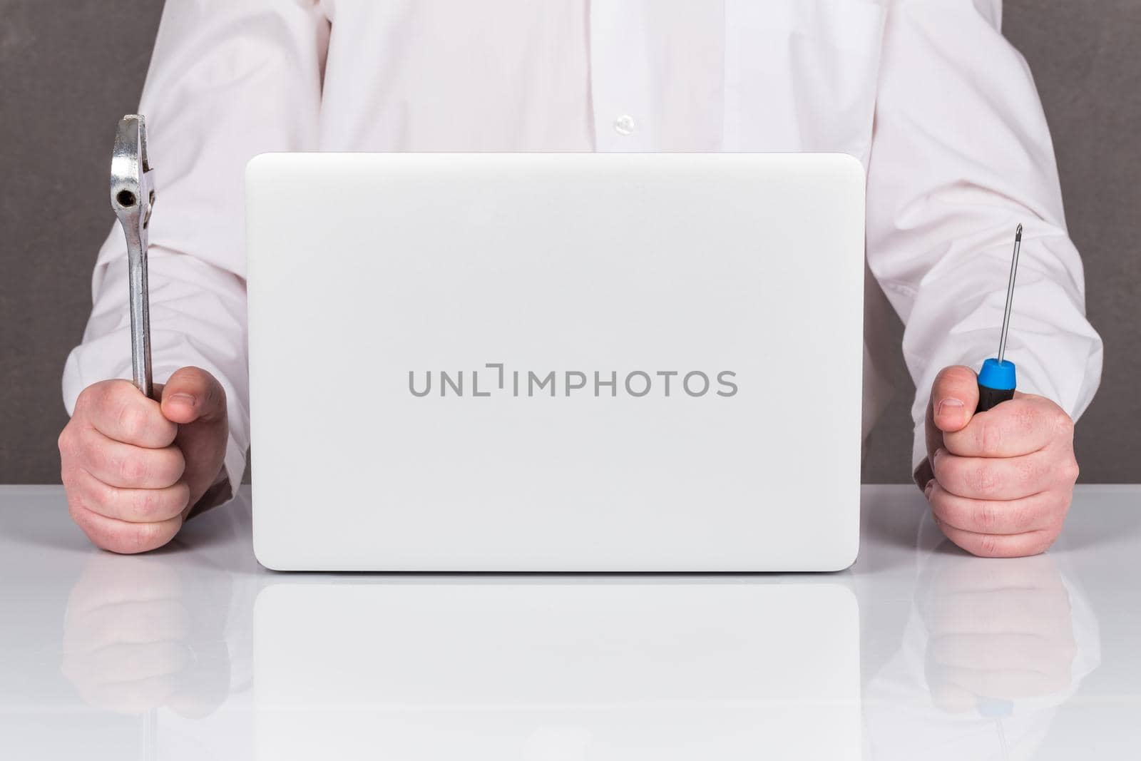 Close-up Of Technician Repairing Laptop At Desk