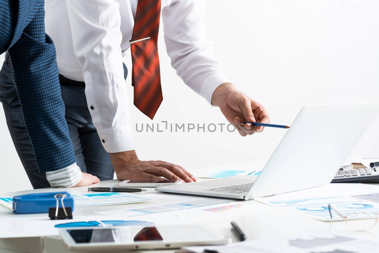 Businessman and businesswoman stand near desk with financial annual report. Business people meeting in conference room. Business idea presentation and analysis. People communication and discussion