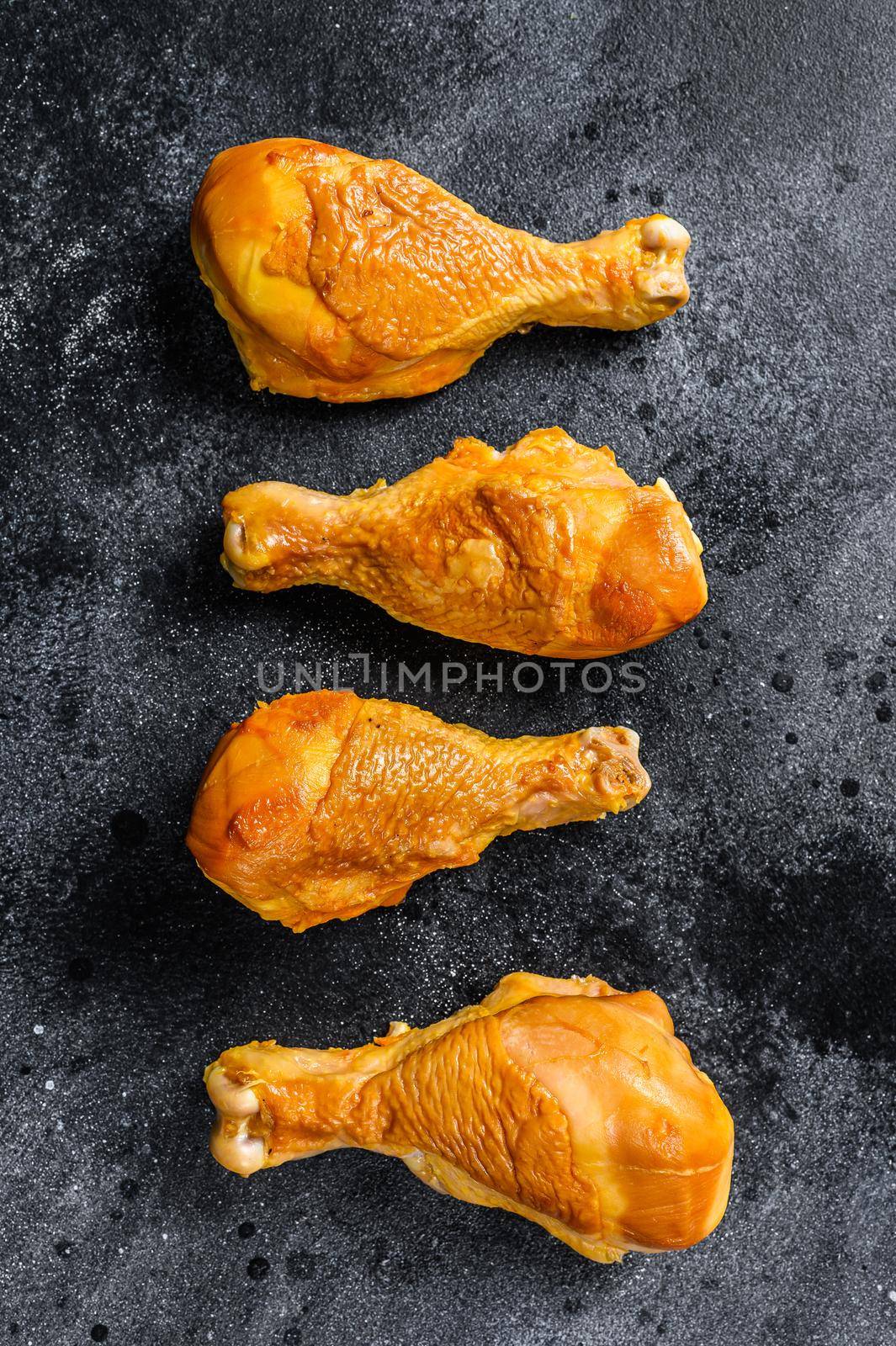 Spicy Smoked chicken leg drumsticks on a kitchen table. Black background. Top view.