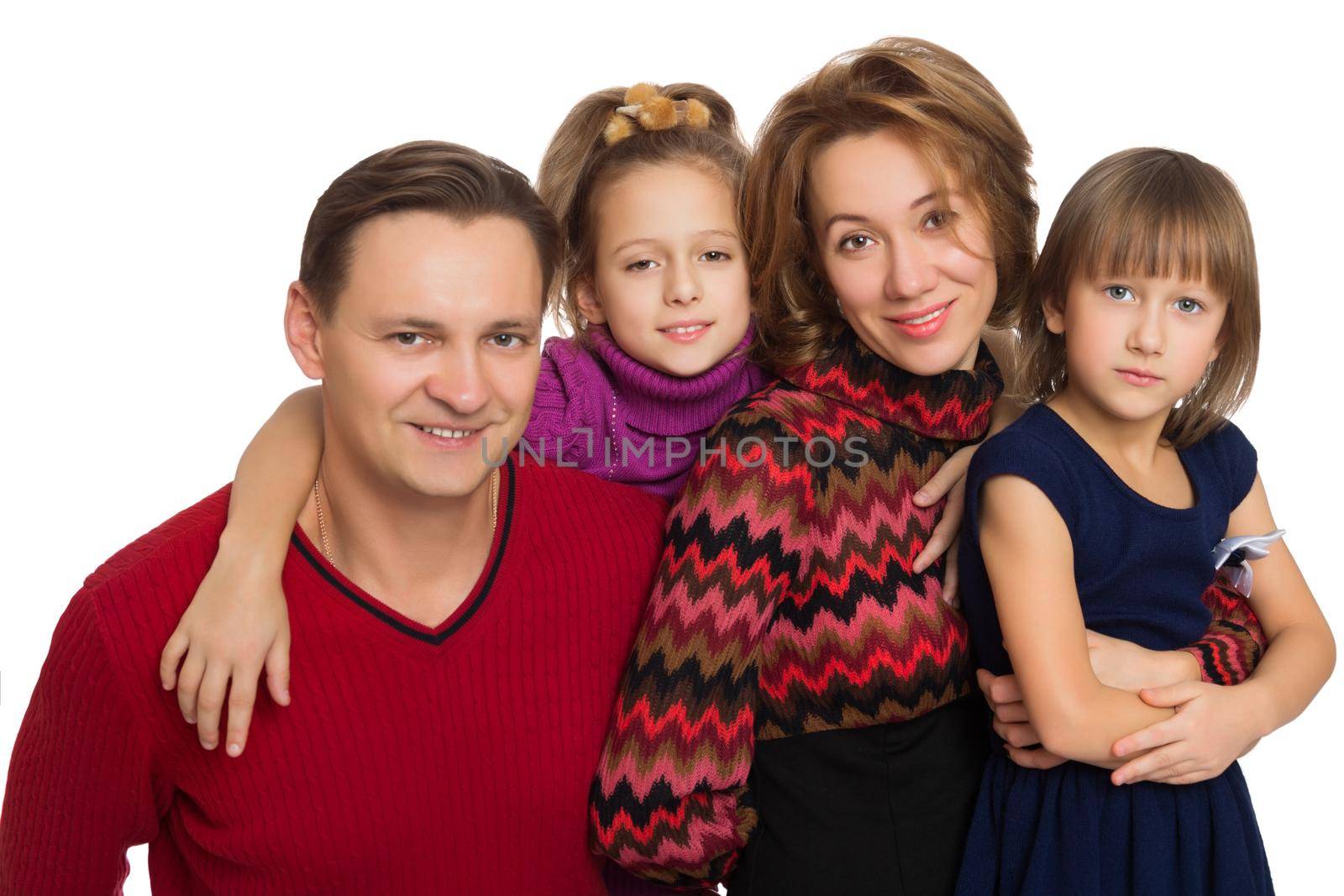 Portrait of a friendly young family of 4 people. Dad, mom and two cute daughters. The girls hug their parents . Close-up - Isolated on white background