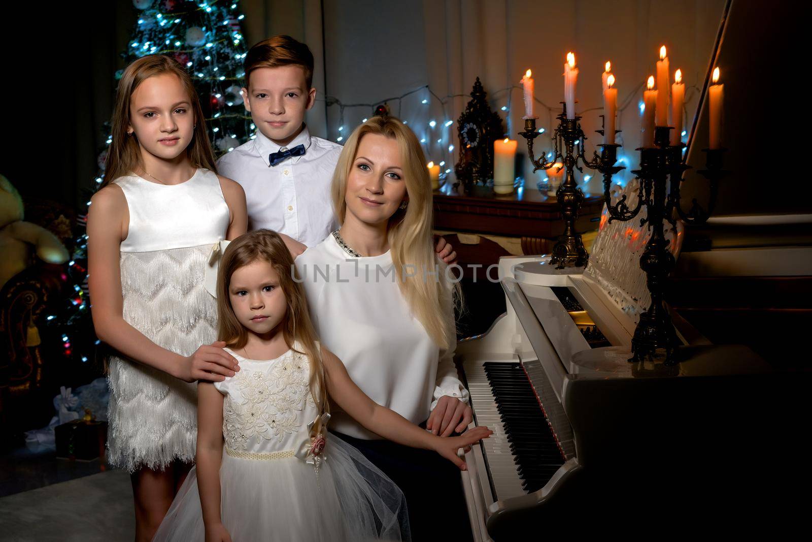 Happy mother with children near a white grand piano by kolesnikov_studio