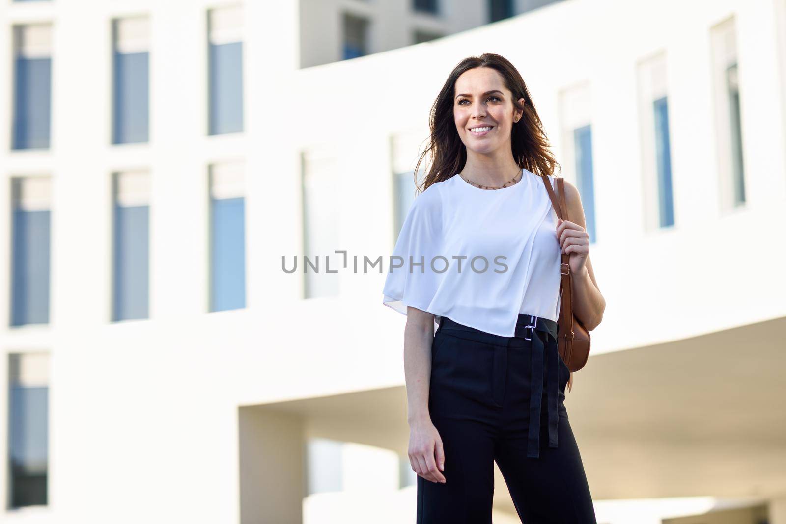 Caucasian female entrepreneur in formal clothes. Confident businesswoman standing outside an office building.