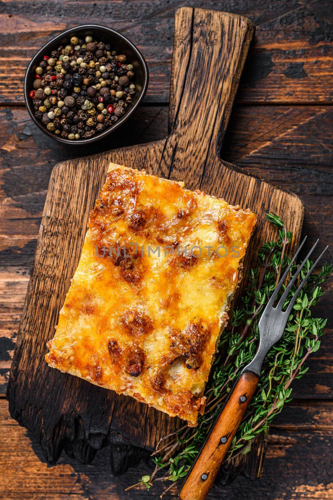 Italian Lasagna with bolognese sauce and mince beef meat. Dark Wooden background. Top view.