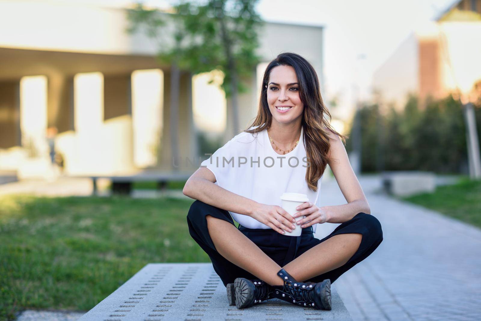 Middle-aged woman taking a coffee break at university. Beautiful girl with highlights hairstyle.