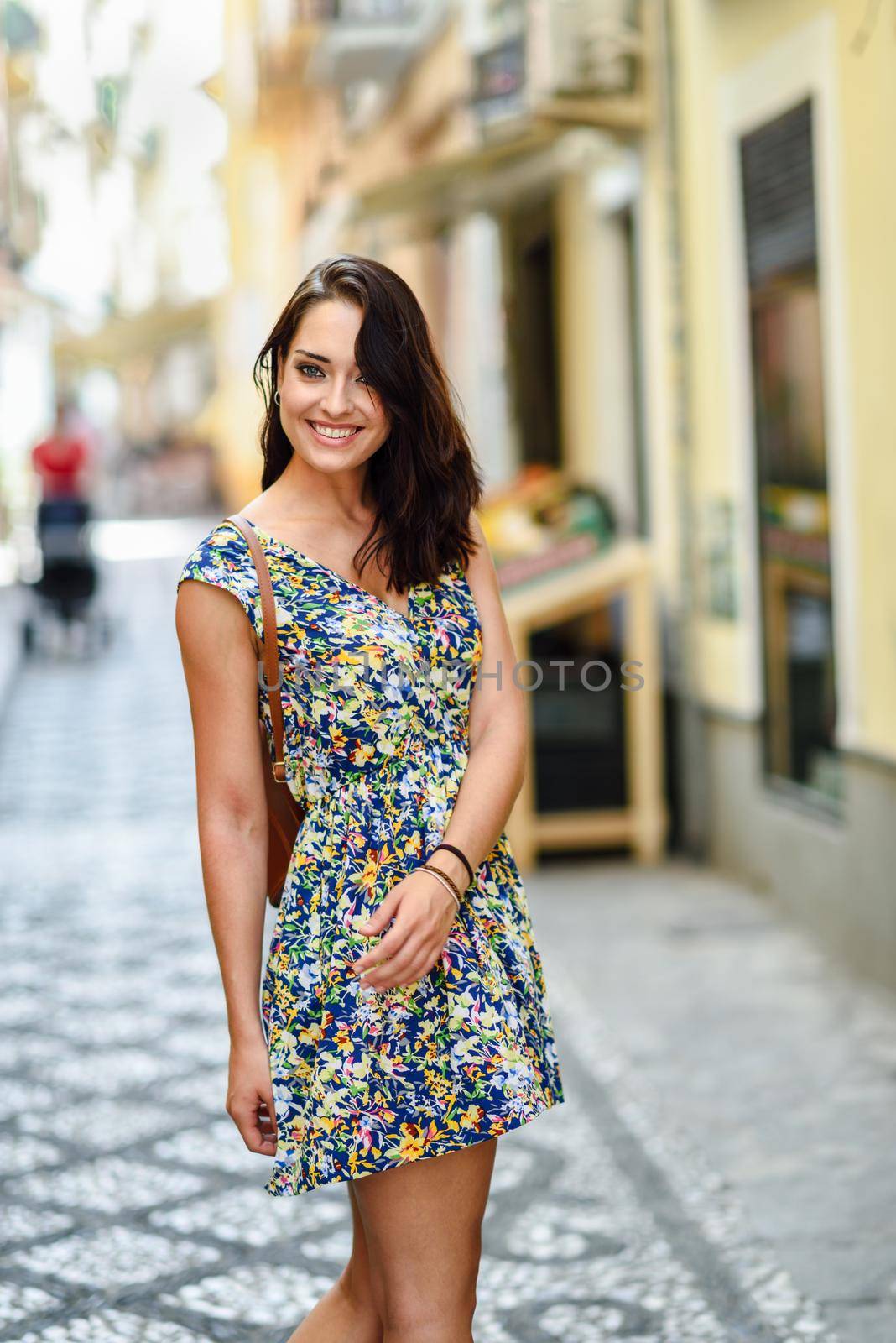 Young woman with blue eyes with brown wavy hair outdoors by javiindy