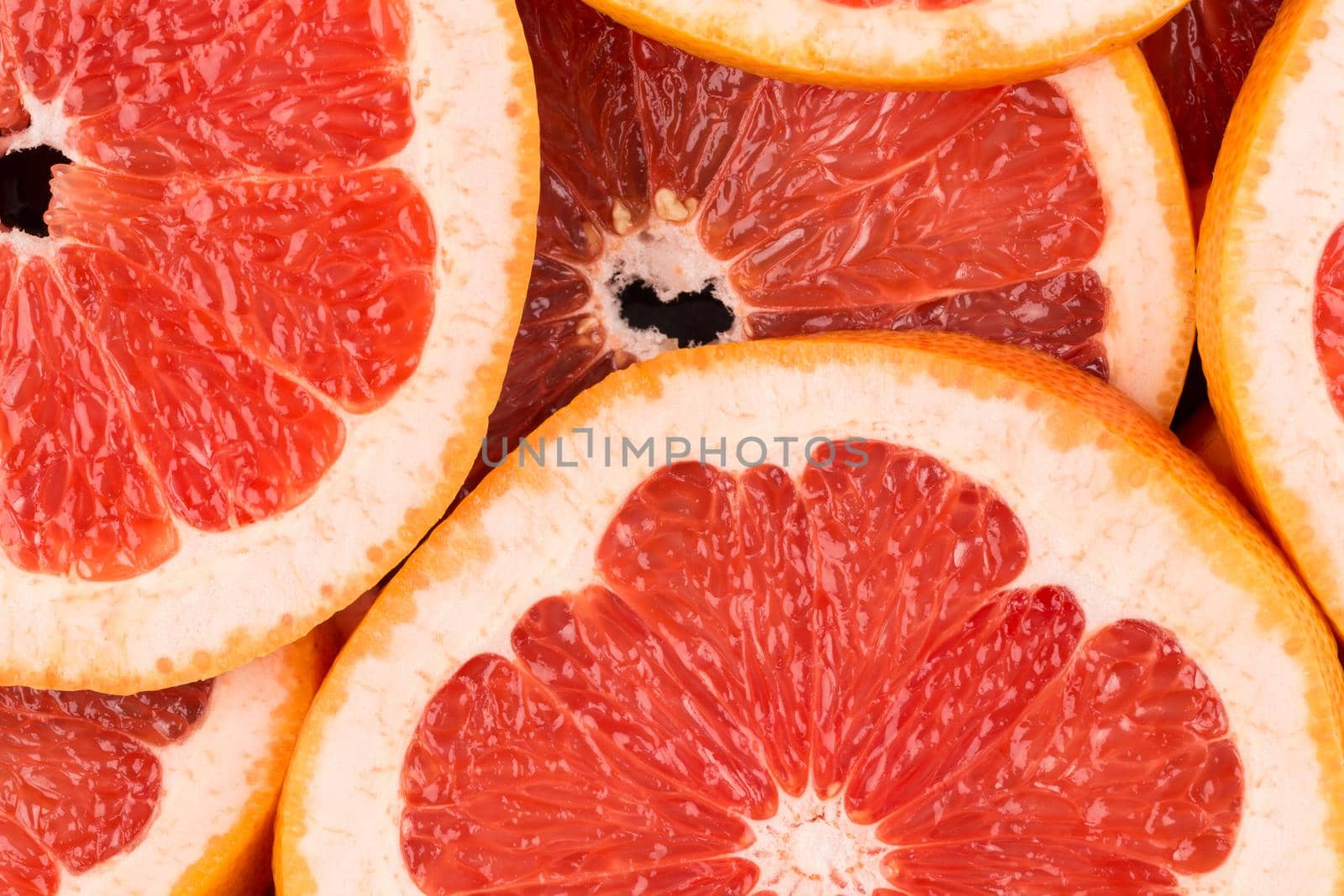 Abstract red background with citrus-fruit of grapefruit slices. Close-up