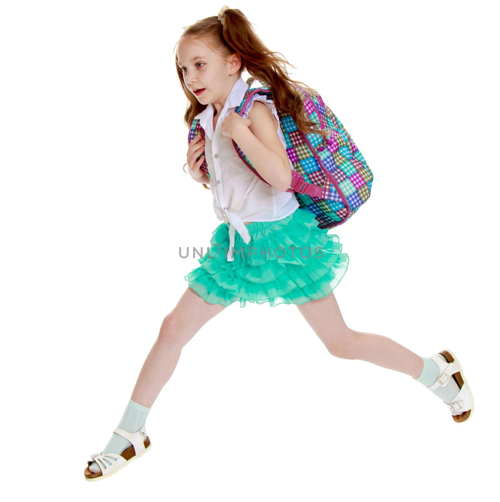 Joyful little girl with long hair to the waist which wire braided white ribbons. In a white shirt without a pattern and green short skirt. Girl jumping over obstacles big step - Isolated