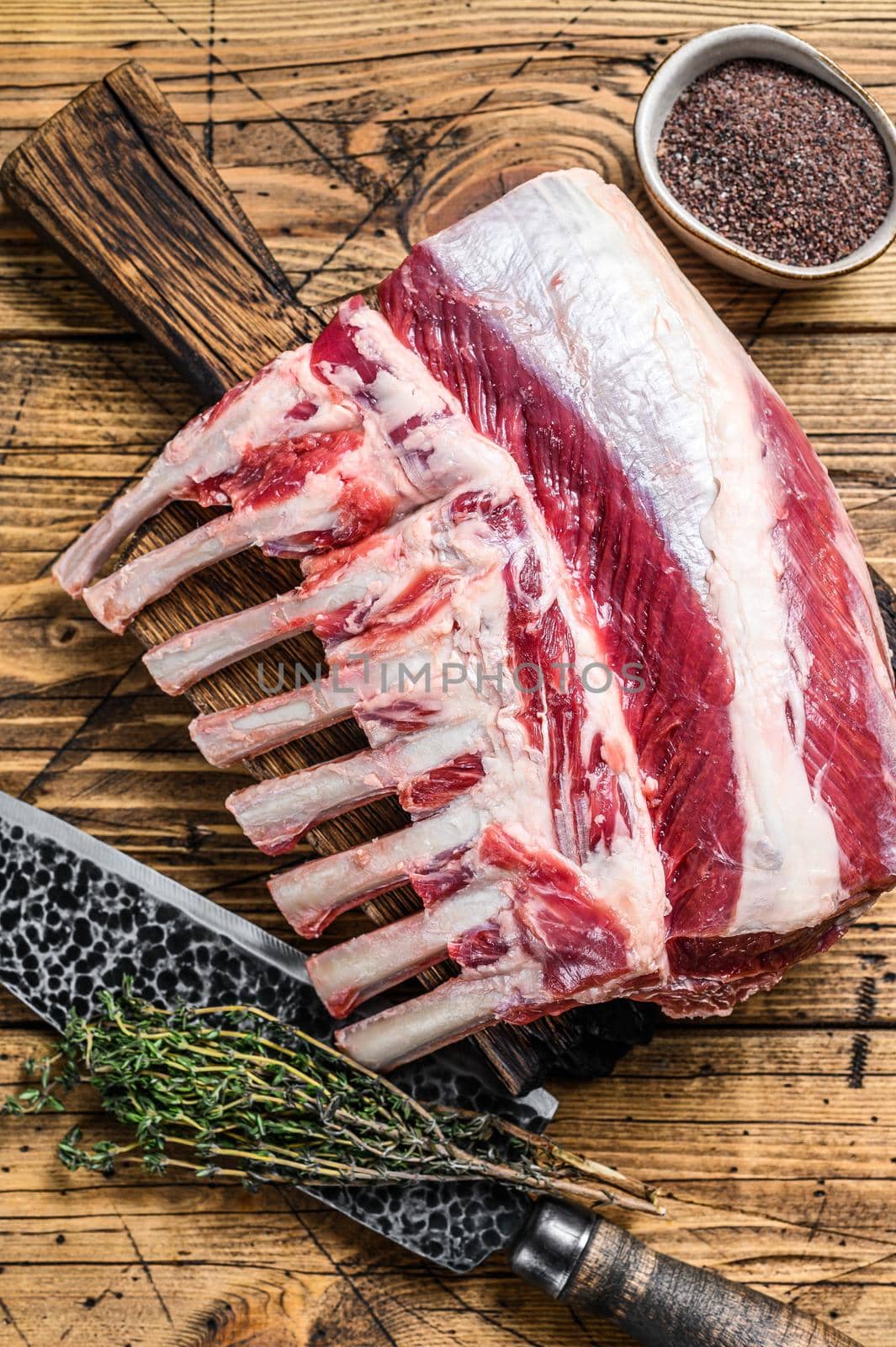 Raw Lamb ribs rack on a cutting board with knife. wooden background. Top view.