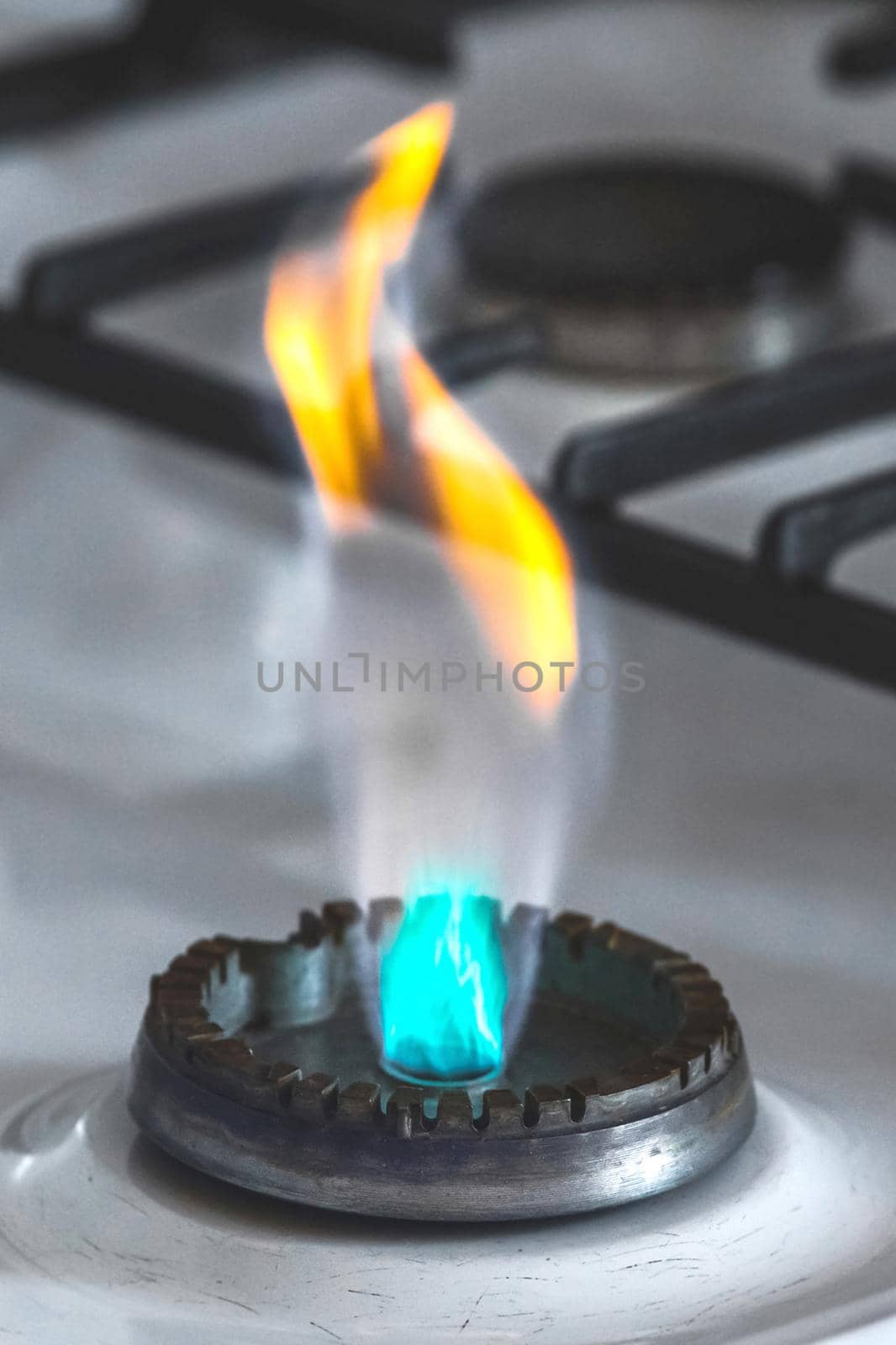 Gas burner with flame from a hole on a gas stove, close-up.