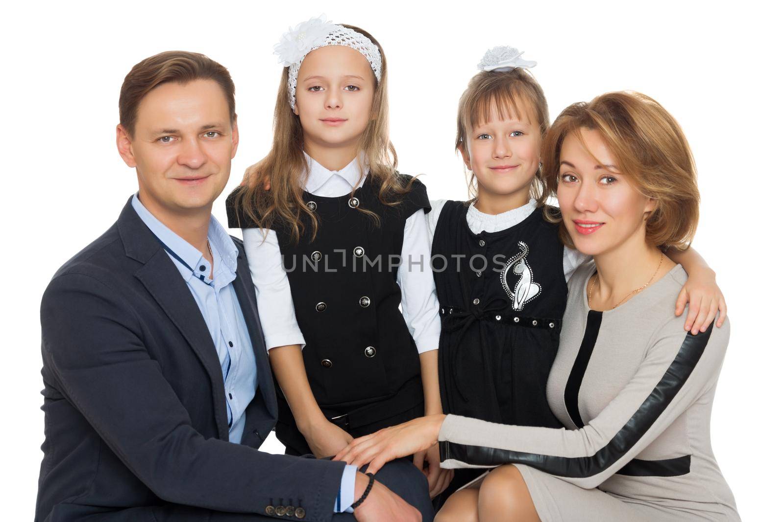 Happy Young family of 4 people . Mom, dad, and two adorable schoolgirl daughter - Isolated on white background