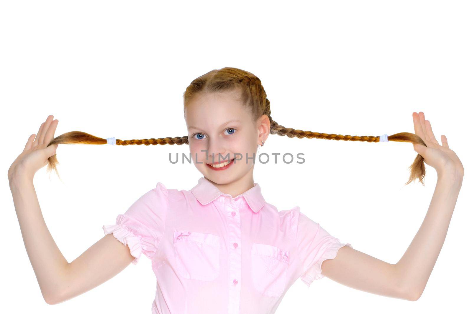 A beautiful little girl is pulling herself in pigtails. The concept of education, advertising, children's emotions. Isolated on white background.