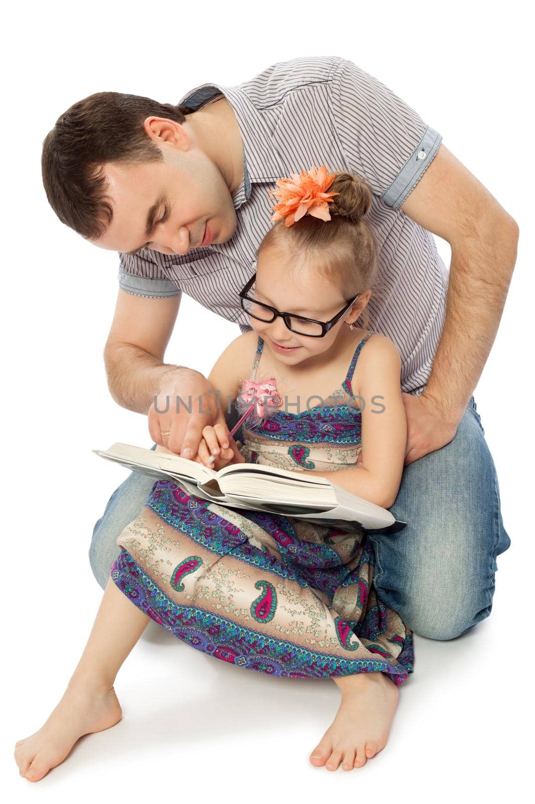 Father and daughter sitting on the floor and read a book. Dad points a finger at the page in the book-Isolated on white background
