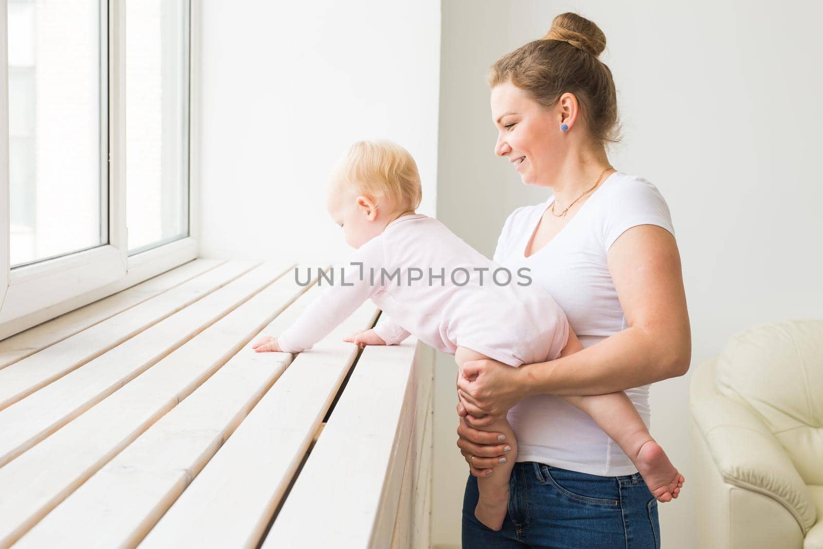 Childhood, family and motherhood concept - Mother with her baby playing at living room.